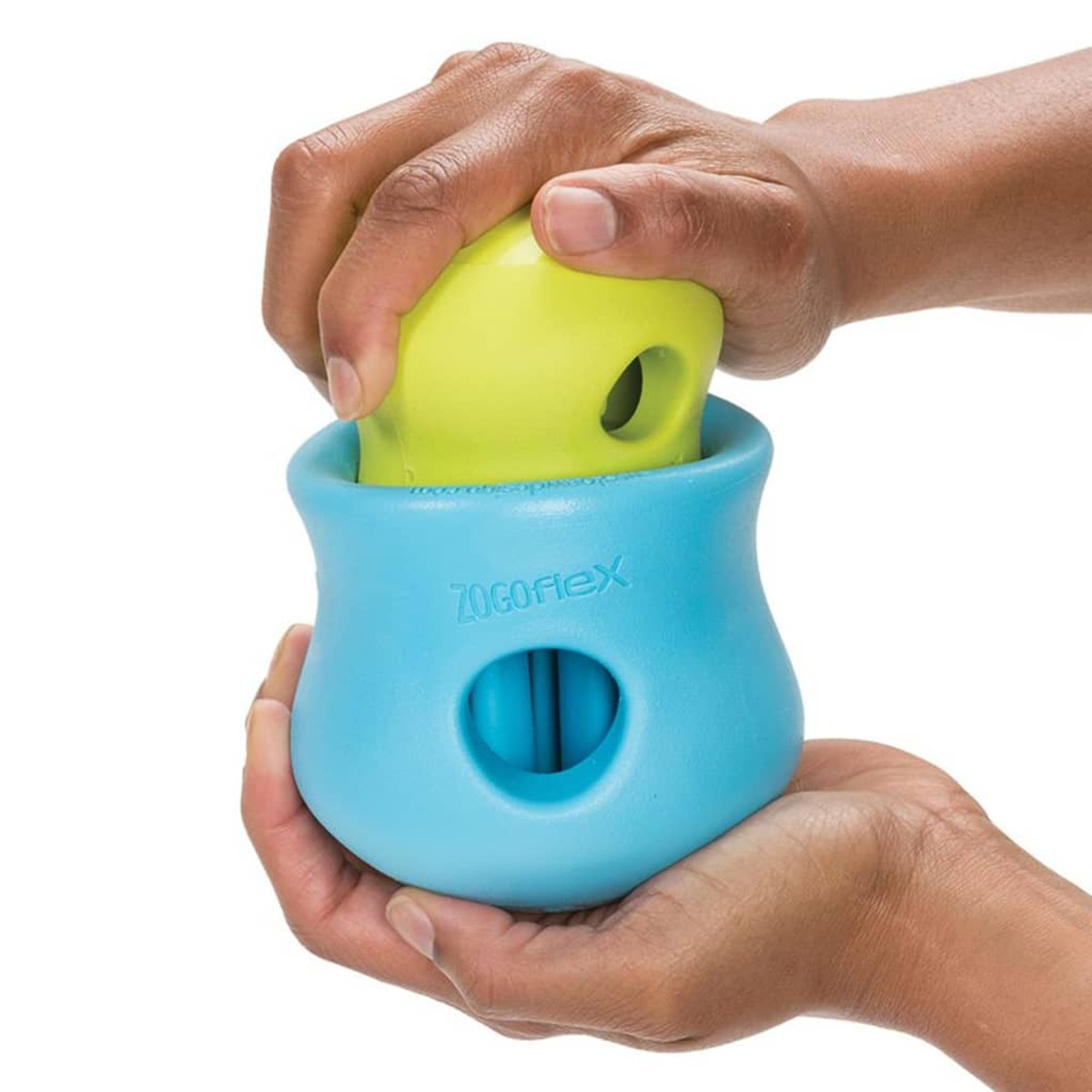 Mani che tengono un contenitore blu con un giocattolo verde all'interno, etichettato 'Zogoflex'.