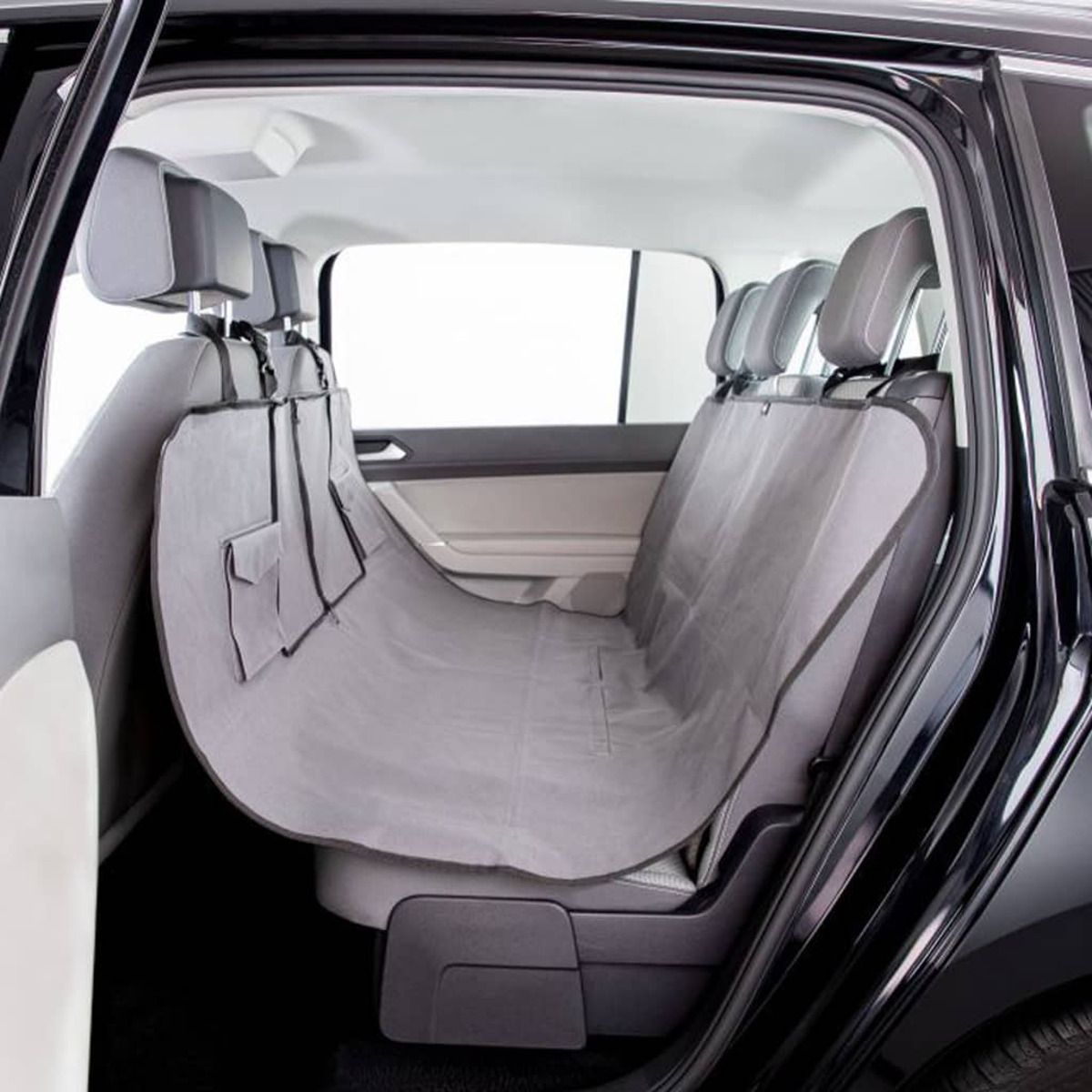 Ein grauer Autositzbezug. Der Bezug befindet sich in einem Auto. Der Bezug hat Taschen und Haken.