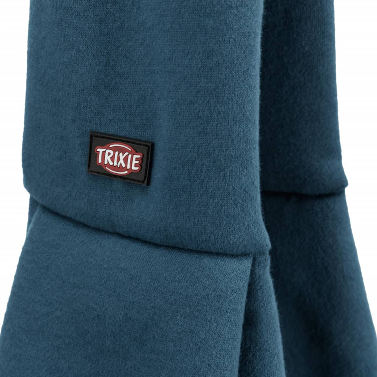 Nahaufnahme eines tealblauen Stoffes mit einem Trixie-Markenaufnäher auf der Vorderseite.