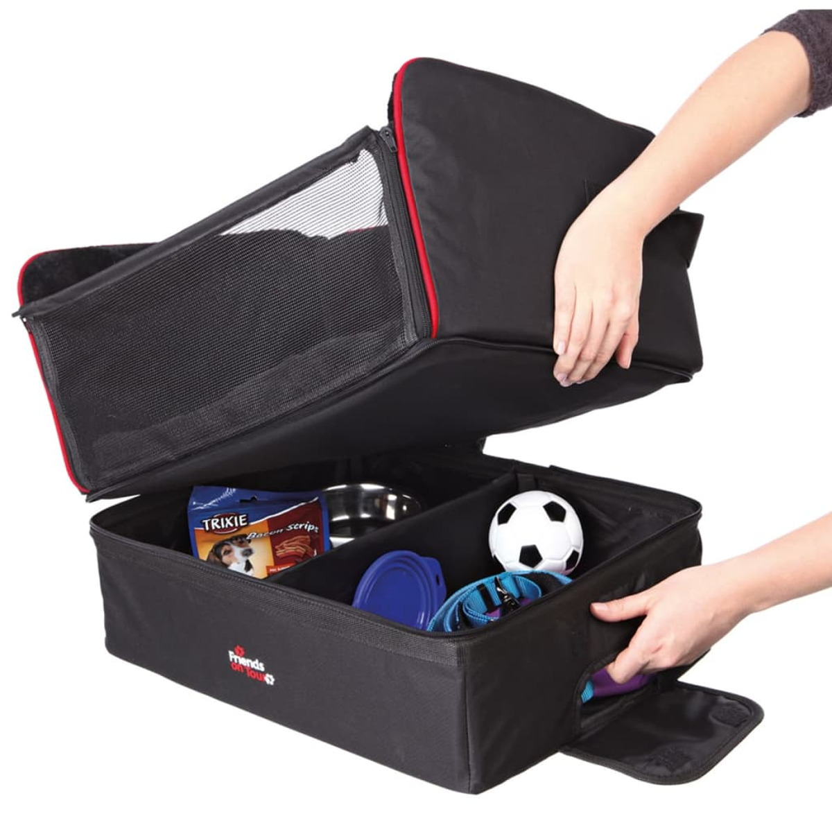 Eine schwarze Haustiertasche mit offenen Fächern, die Tierzubehör enthält, wird von Händen geöffnet.
