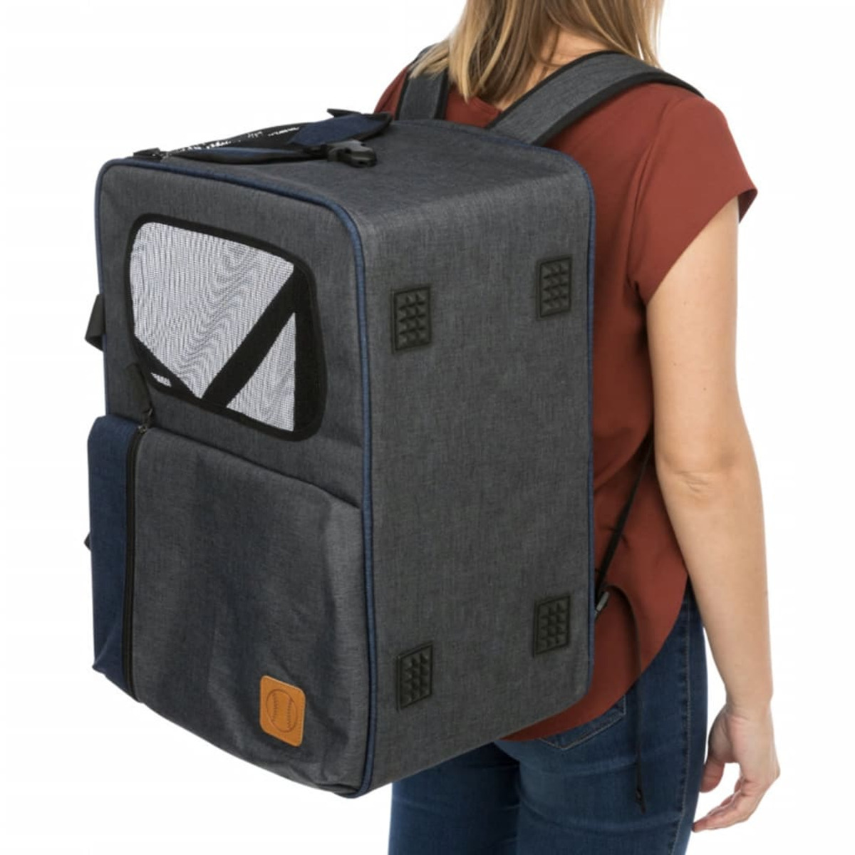Eine Frau trägt einen Rucksack-Haustierträger. Der Träger ist grau und blau, mit einem Netzfenster.