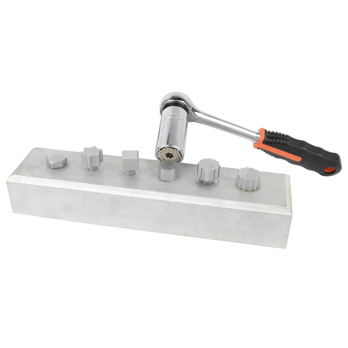 Ein Schraubenschlüssel auf einem Metallblock mit verschiedenen geformten Metallarmaturen.