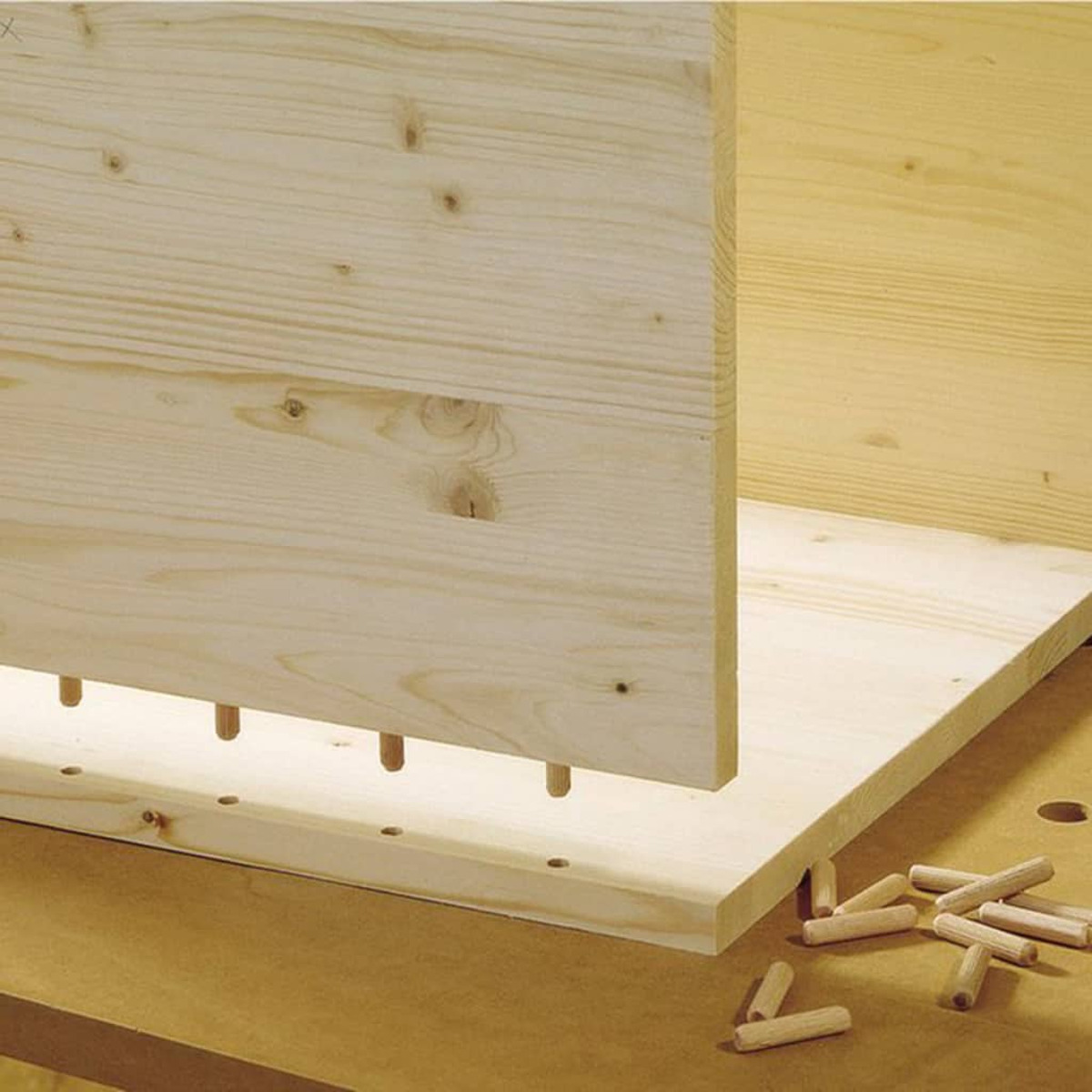 Planches de bois avec chevilles en cours de jonction. Composants d'armoires en bois.