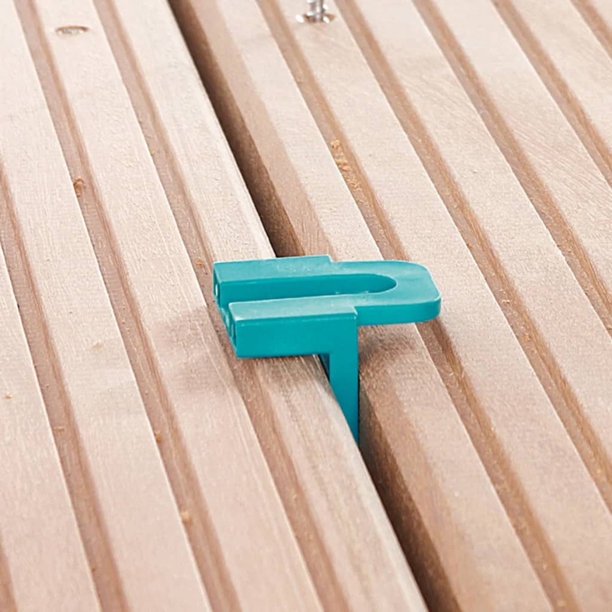 Un connettore color verde acqua è posizionato su un'asse di legno.