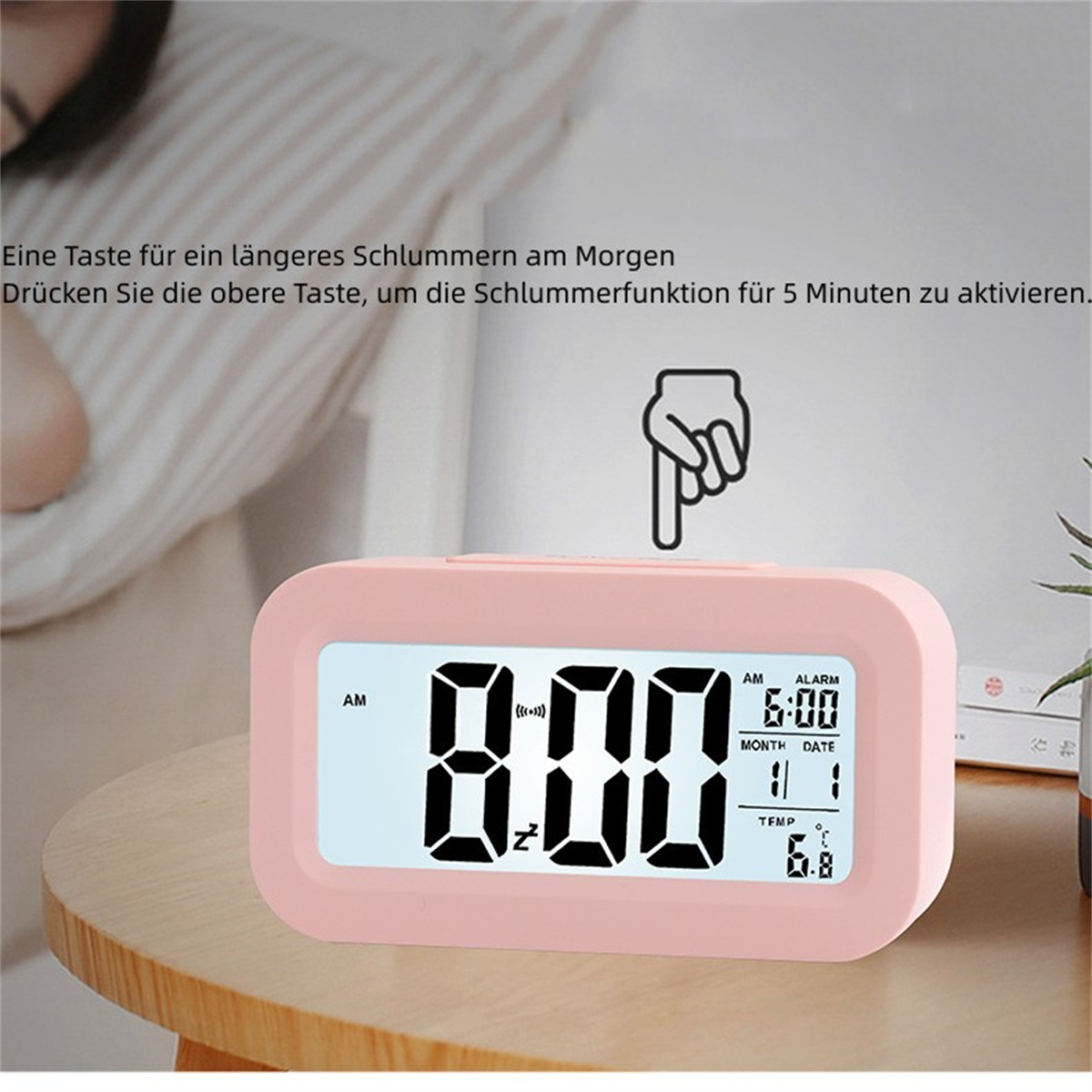 Rosa digitaler Wecker auf einem Holztisch. Die angezeigte Zeit ist 6:00 Uhr morgens.