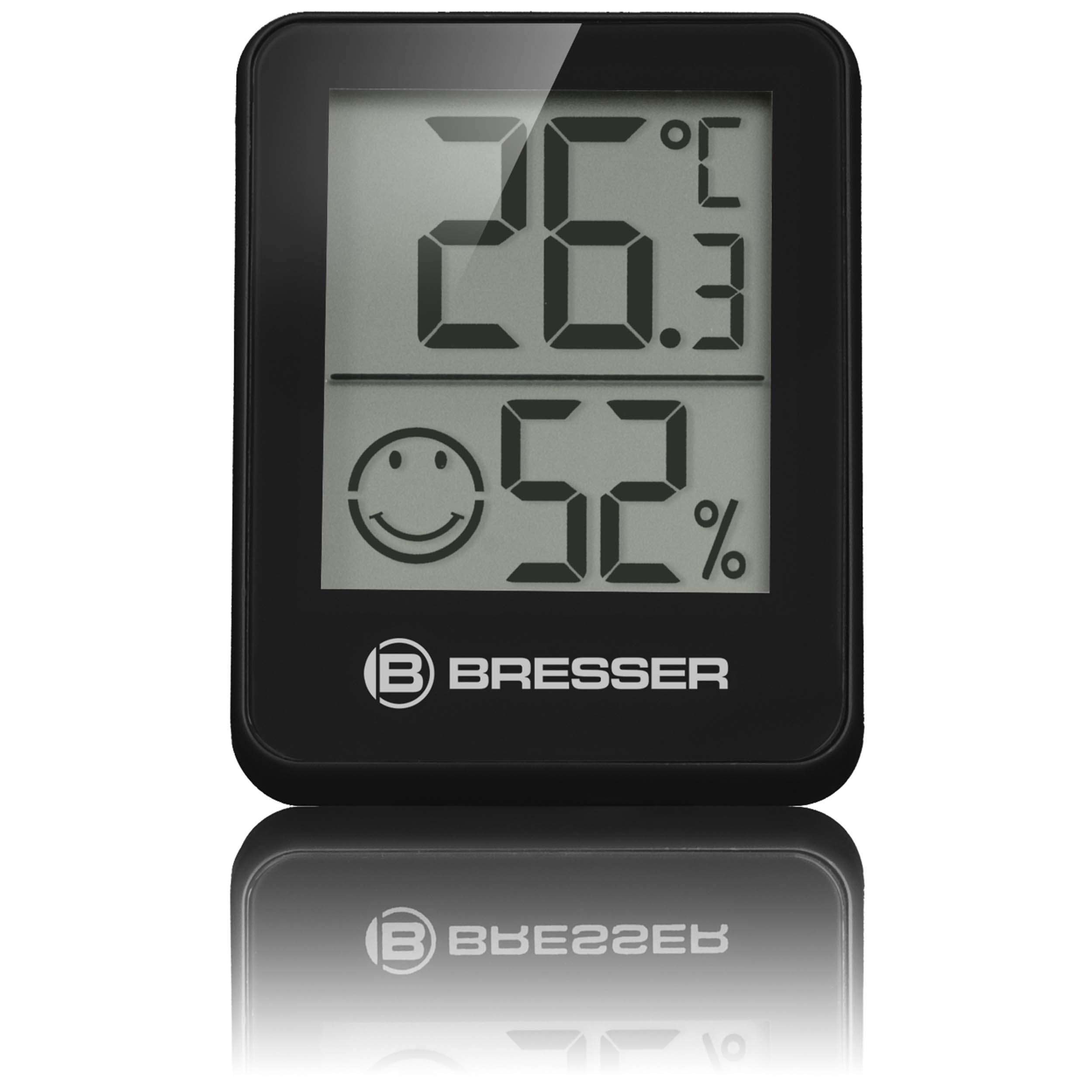Termómetro digital negro mostrando temperatura y humedad con una carita.