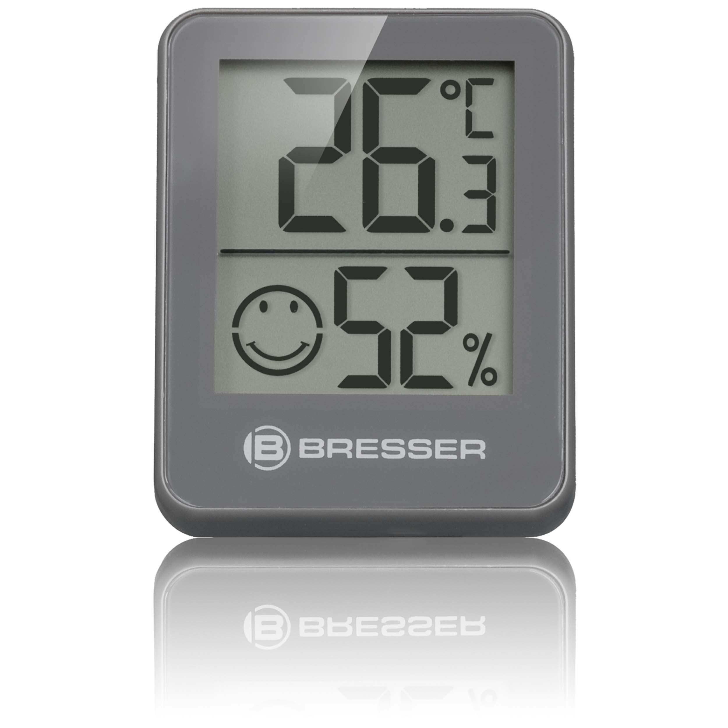 Graues Digitalthermometer mit 26,3°C und 52 % Luftfeuchtigkeit und einem Smiley-Gesicht.