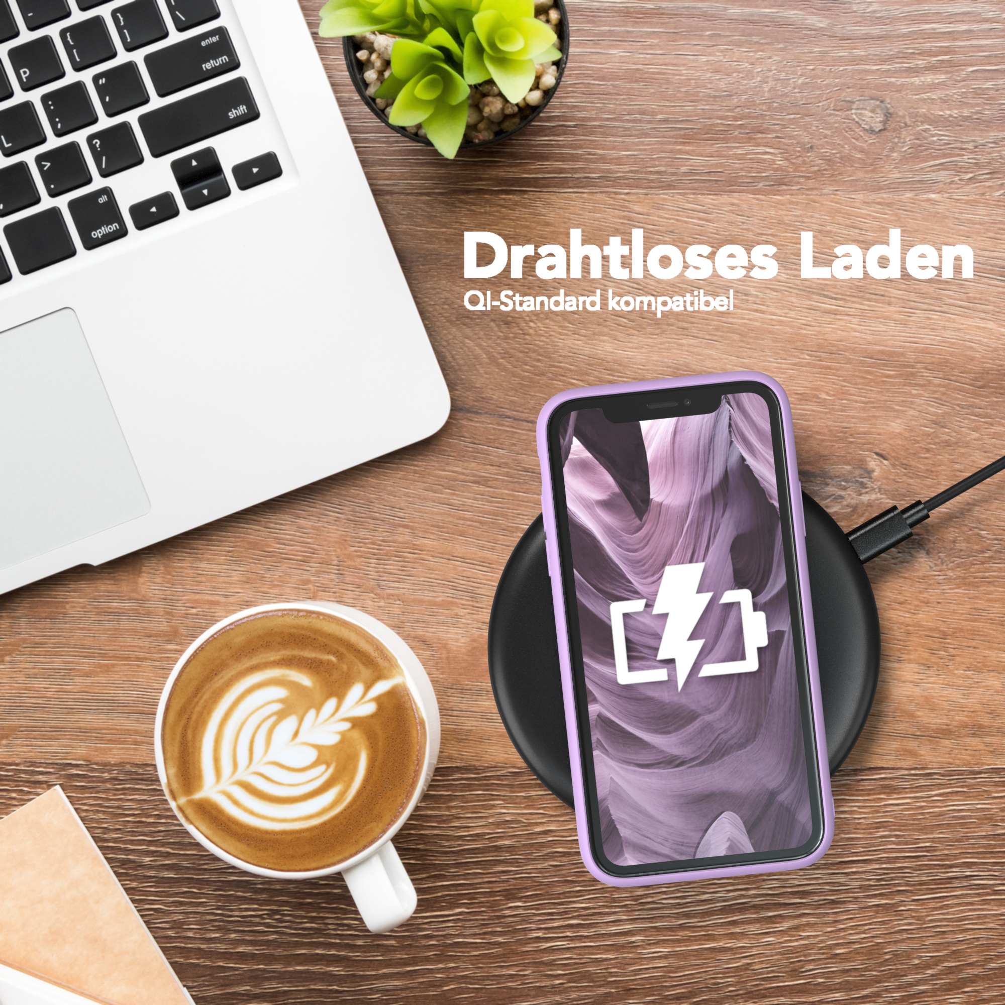Ein Telefon in einer lila Hülle lädt auf einem kabellosen Ladepad neben Kaffee und Laptop.