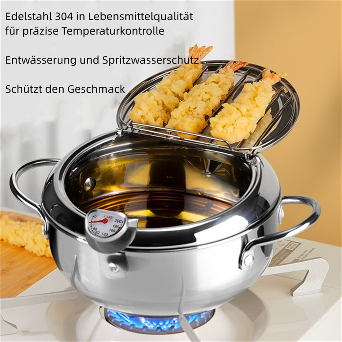 Eine Edelstahl-Fritteuse mit Tempura-Garnelen und einem Thermometer auf einem Herd.