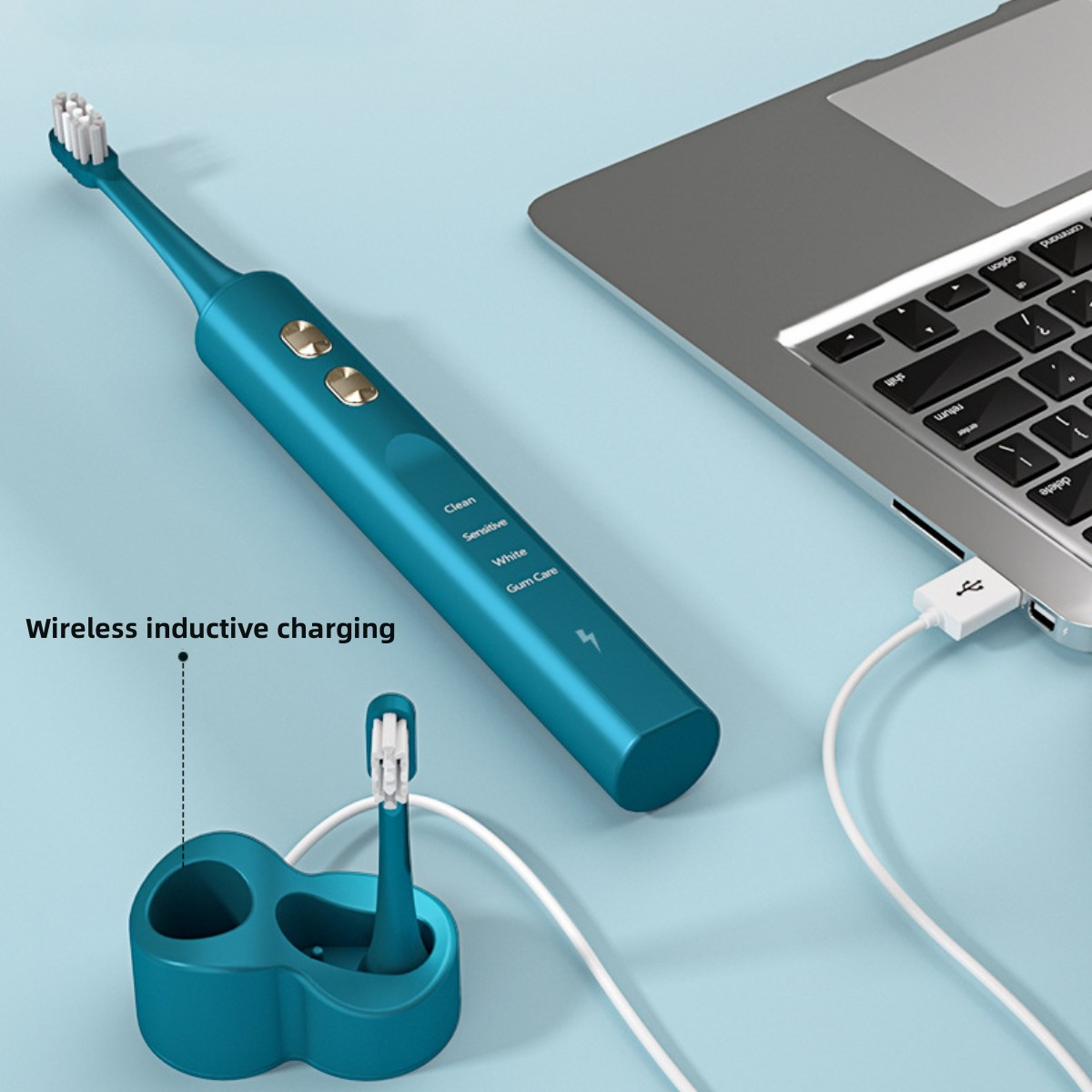Türkisfarbene elektrische Zahnbürste und Ladestation, neben einem Laptop mit USB-Kabel.