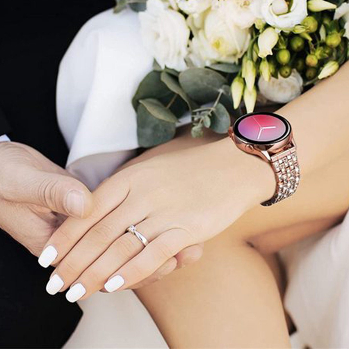 Kobieta nosząca smartwatch i pierścionek na palcu. W kadrze znajduje się ręka mężczyzny.