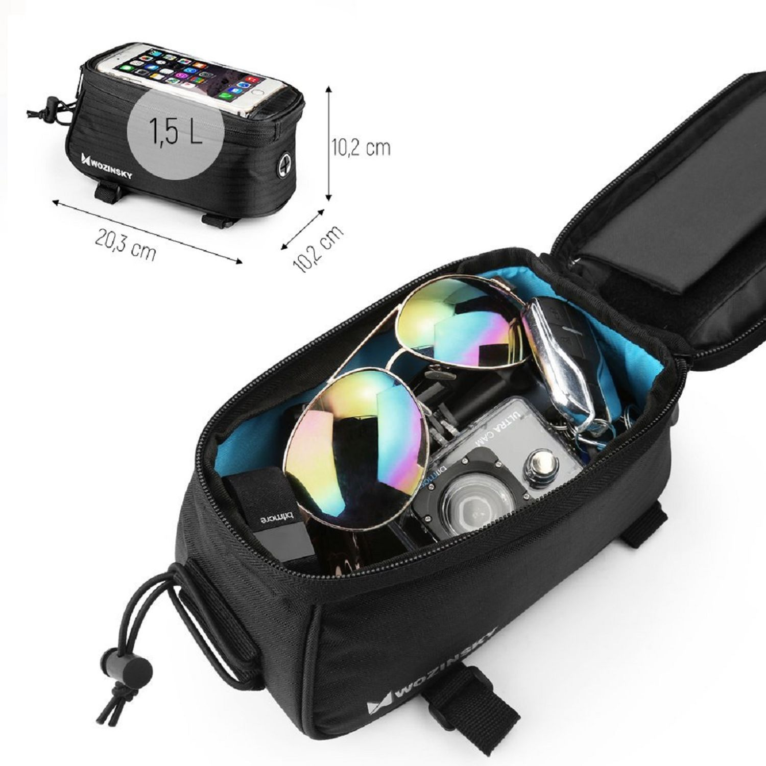 Eine schwarze Tasche mit einem Telefon darin. Sonnenbrille, Schlüssel und eine Kamera sind darin. Die Tasche liegt auf einer weißen Oberfläche.