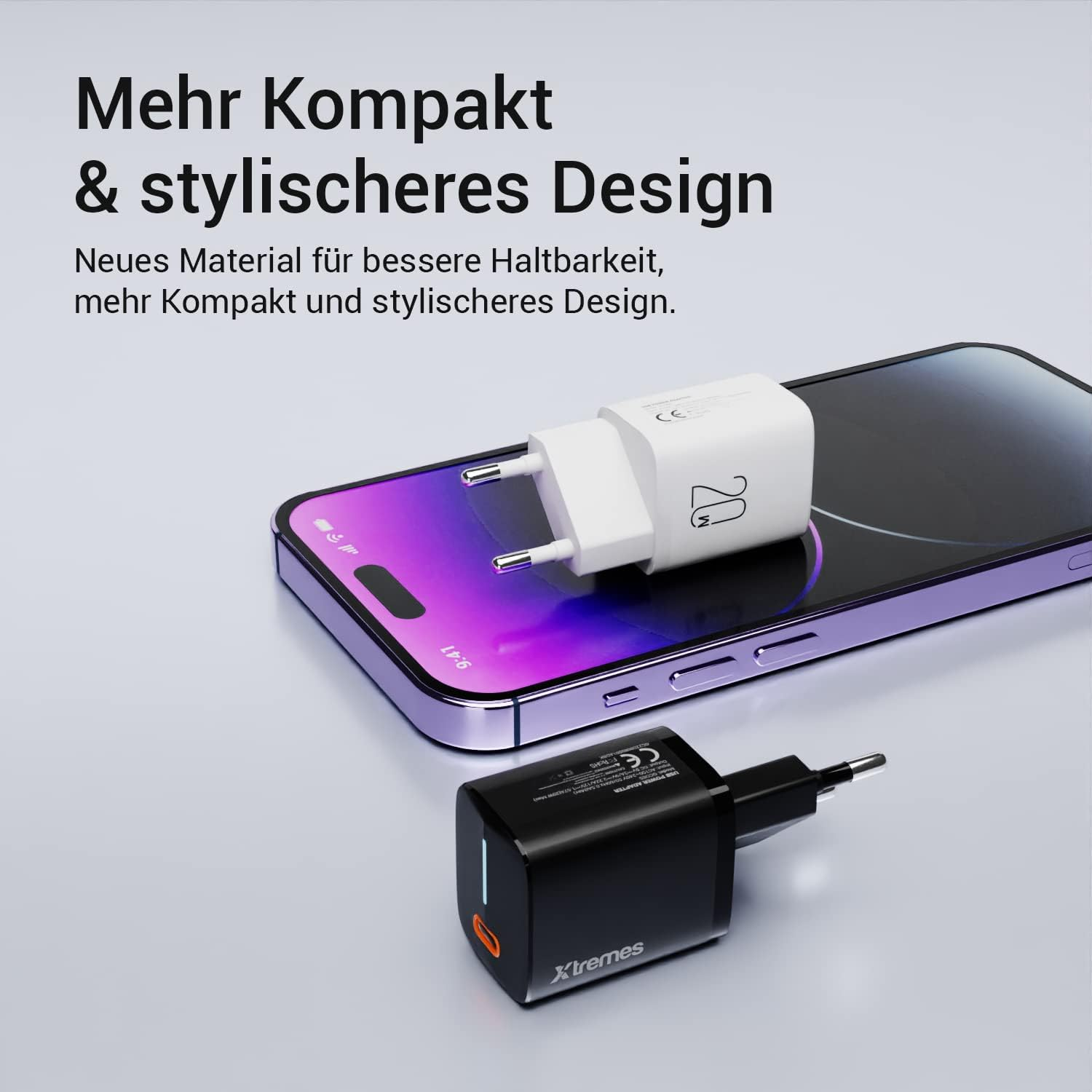 Zwei Ladegeräte, eines schwarz und eines weiß, liegen mit einem Telefon auf einem Tisch. Text: Mehr Kompakt...