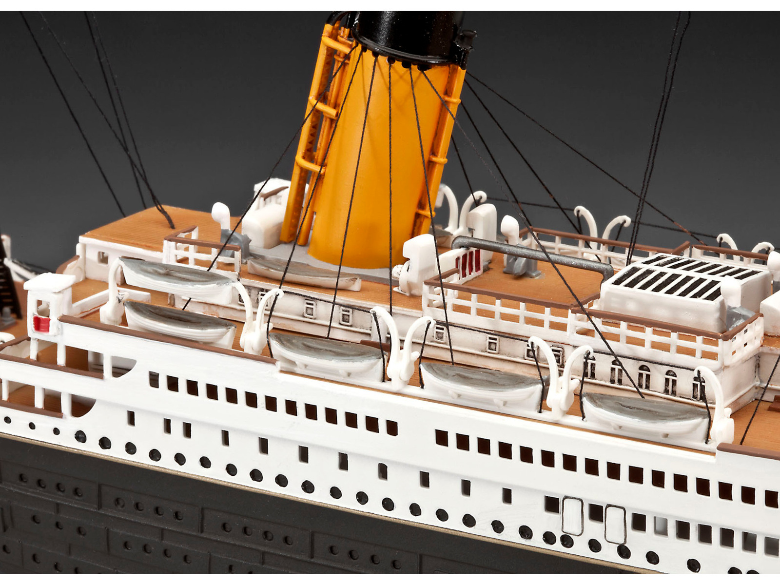 Ein Modell der Titanic, mit weißem Rumpf, braunen Decks und orangefarbenen Schornsteinen. Schwarzer Hintergrund.