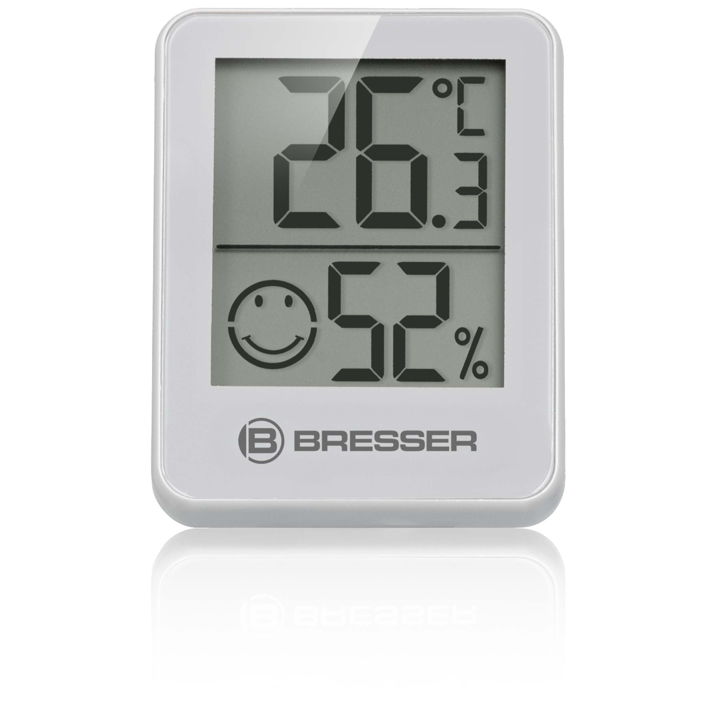 Ein weißes digitales Thermometer mit Smiley und Temperaturanzeige von 26,3°C und 52 % Luftfeuchtigkeit.