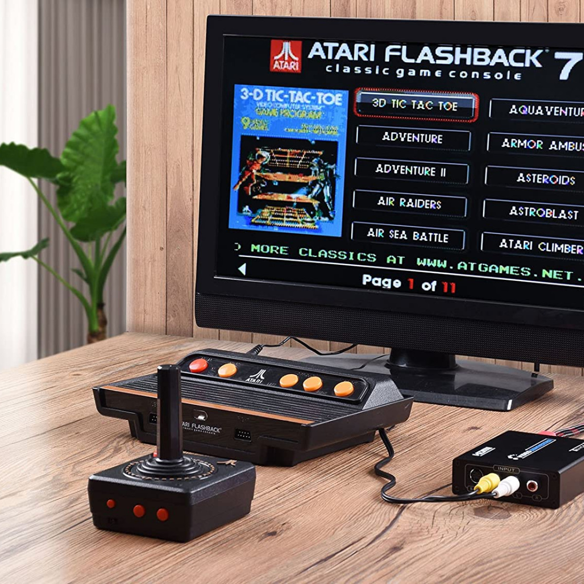 Konsola do gier Atari Flashback 7 z kontrolerem i grami na ekranie telewizora.
