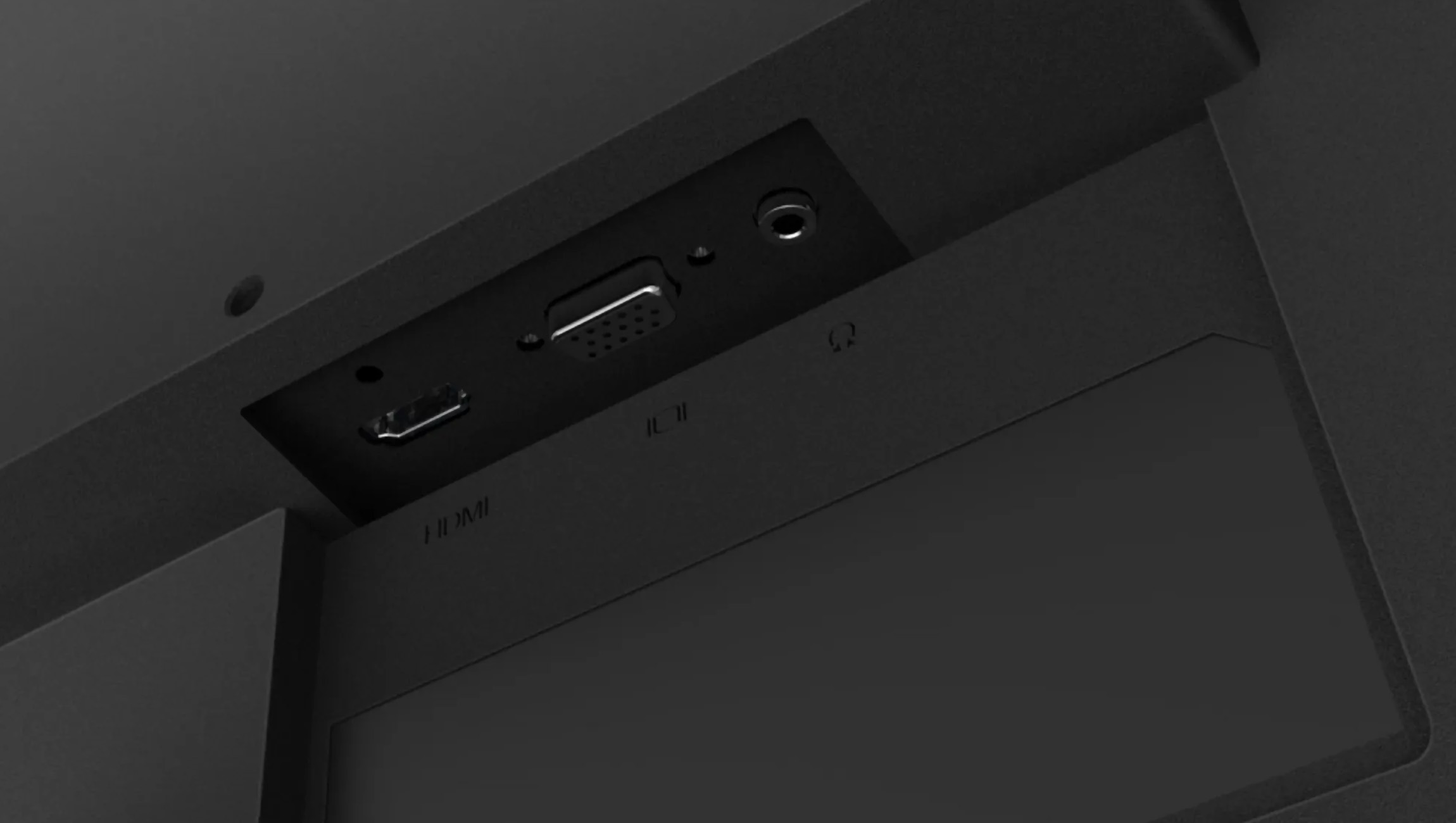 Zbliżenie złączy monitora na ciemnej powierzchni, w tym HDMI, VGA i wejście audio.