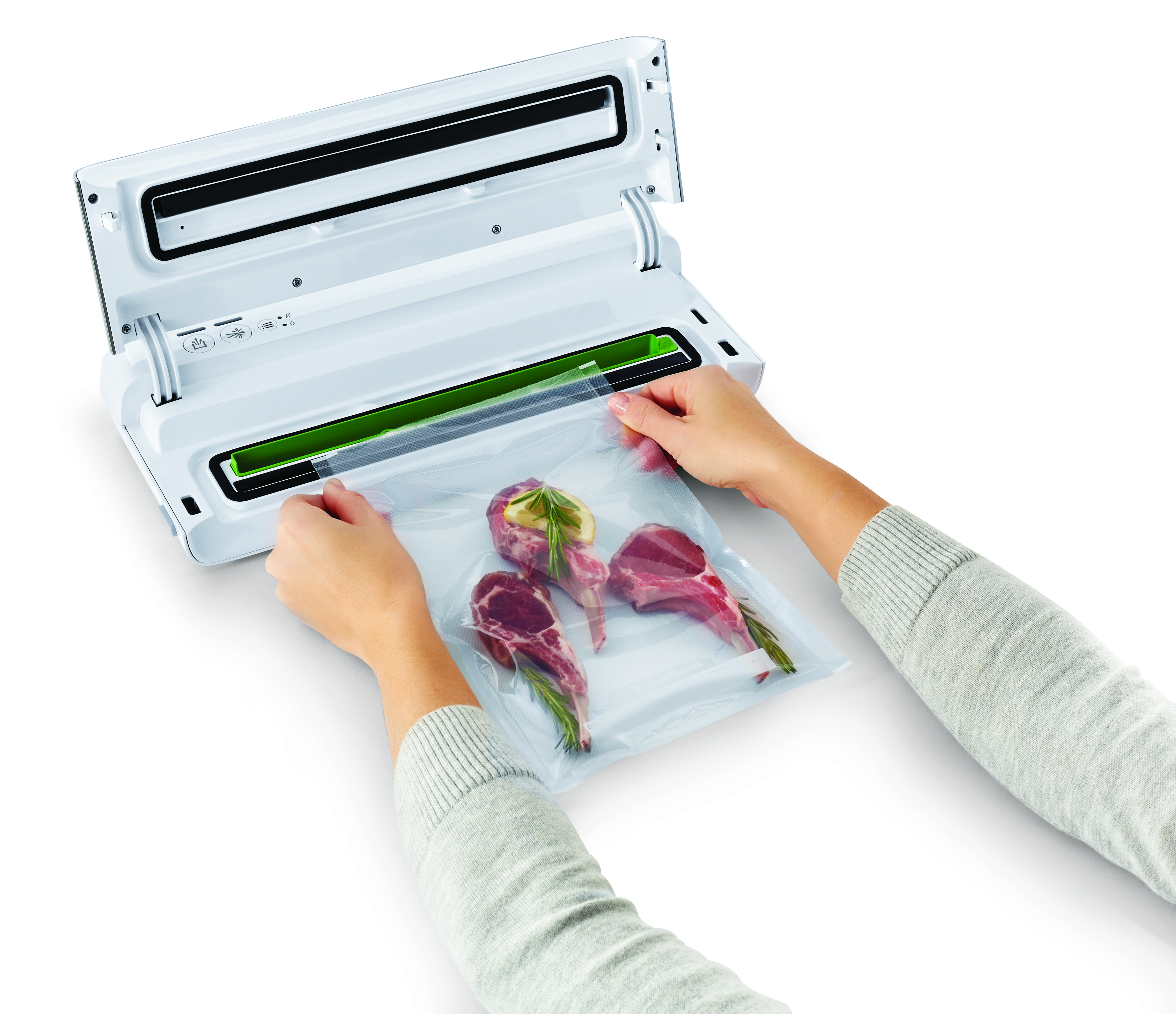 Osoba trzyma zgrzewarkę próżniową do żywności z woreczkiem mięsa, które ma zostać zgrzane.