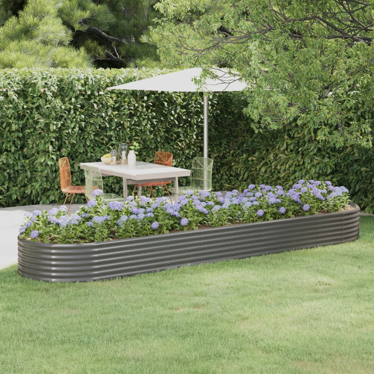 Szene im Freien mit Blumenbeet, Tisch, Stühlen und Sonnenschirm. Eine Hecke umgibt den Bereich.