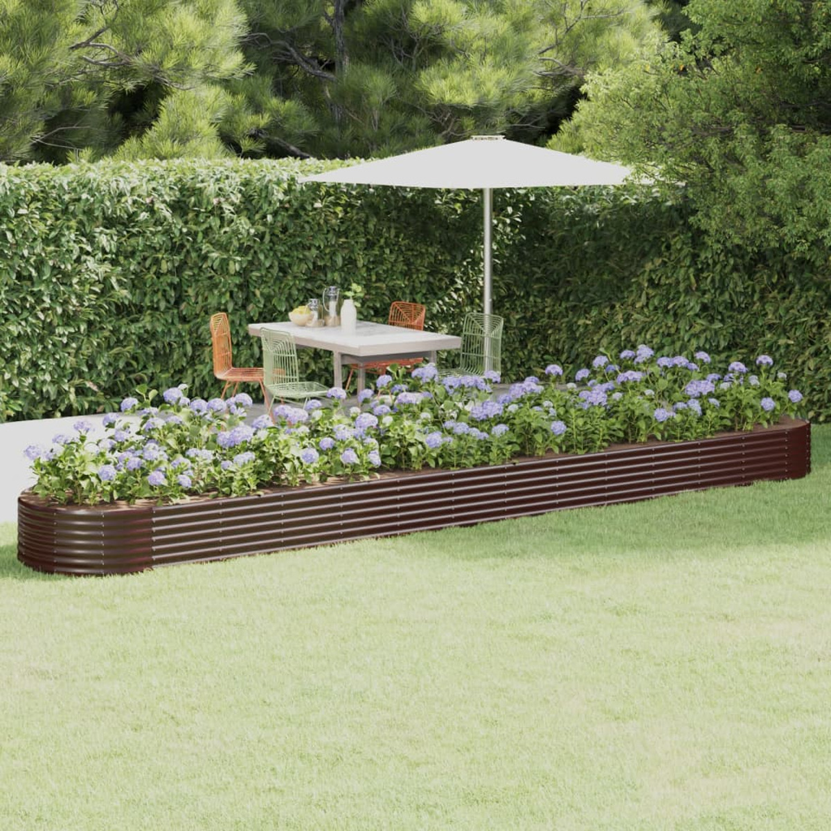 Eine Gartenszene mit einem erhöhten Beet voller Blumen. Ein Tisch und ein Sonnenschirm im Hintergrund.