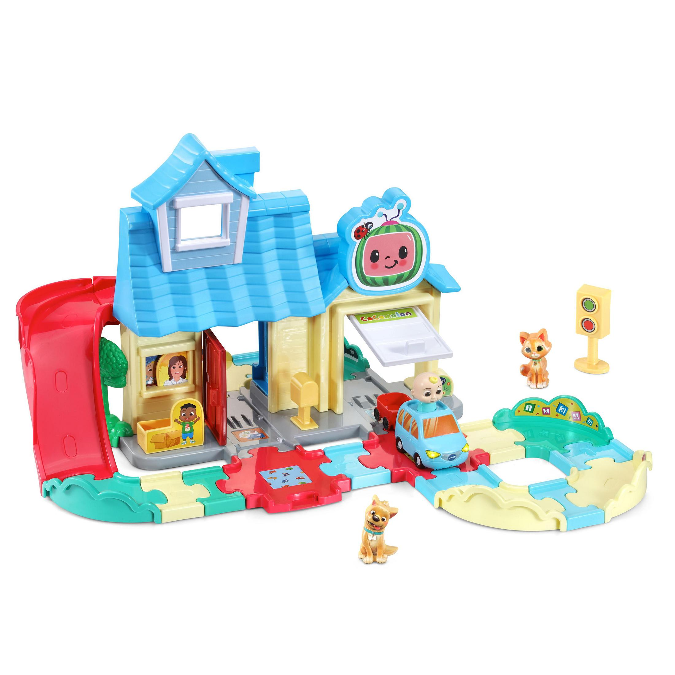 Ein Spielset mit Haus, Auto und Figuren. Eine rote Rutsche und Straßen verbinden die Bereiche.