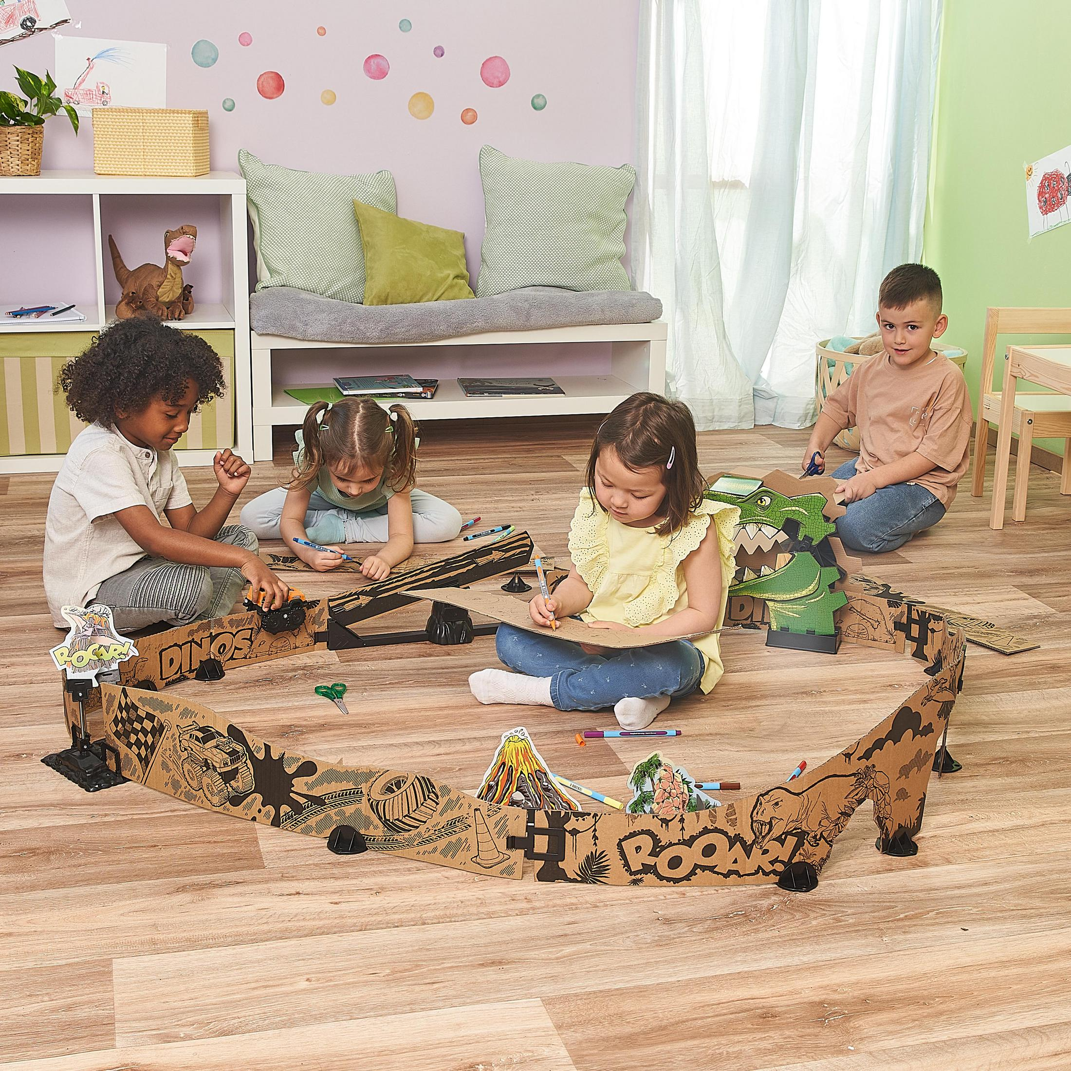 Vier Kinder spielen mit einem Dinosaurier-Themen-Papp-Spielset, zeichnen und basteln.