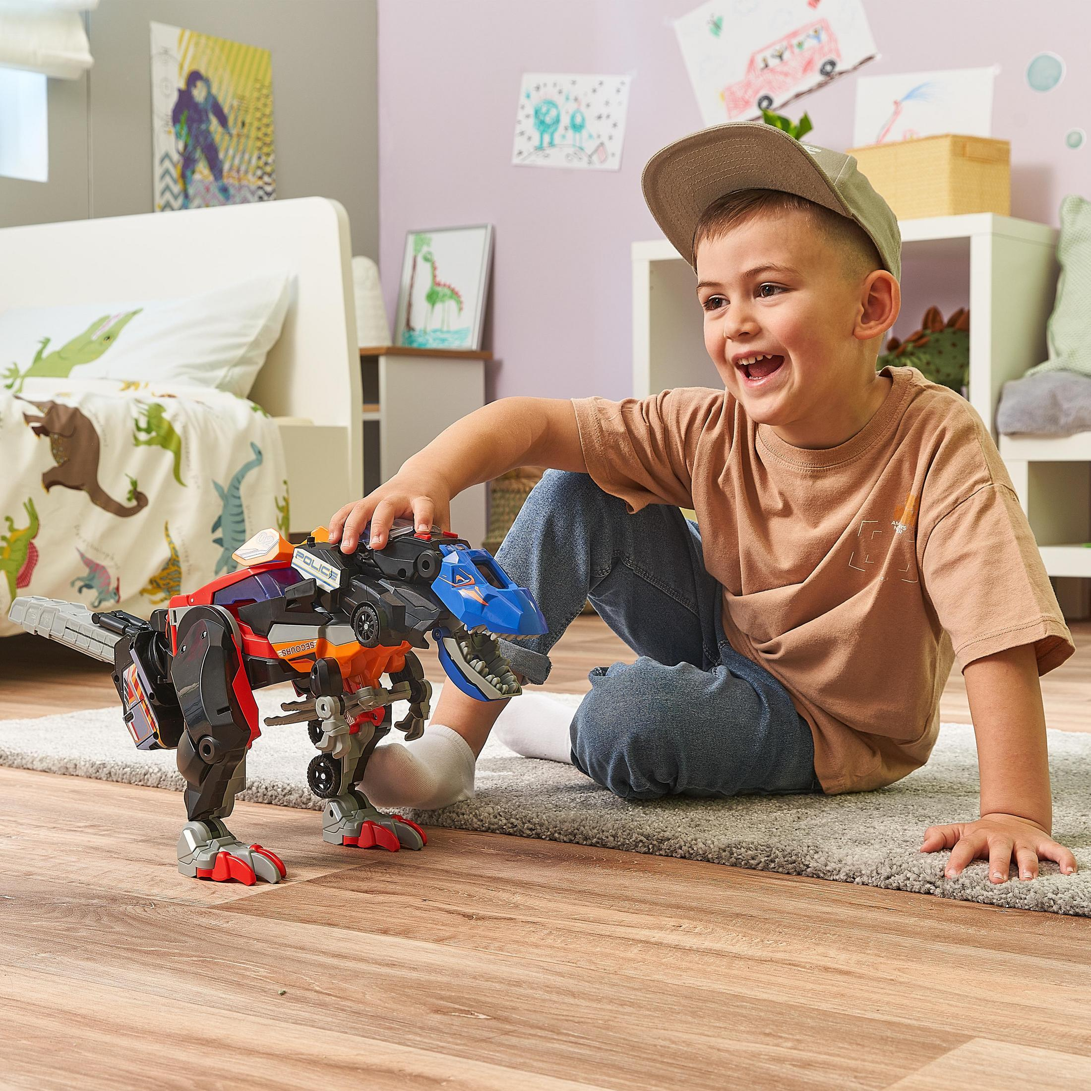 Ein Kind spielt mit einem Spielzeug-Dinosaurier. Der Dinosaurier ist rot und schwarz. Das Kind lächelt.