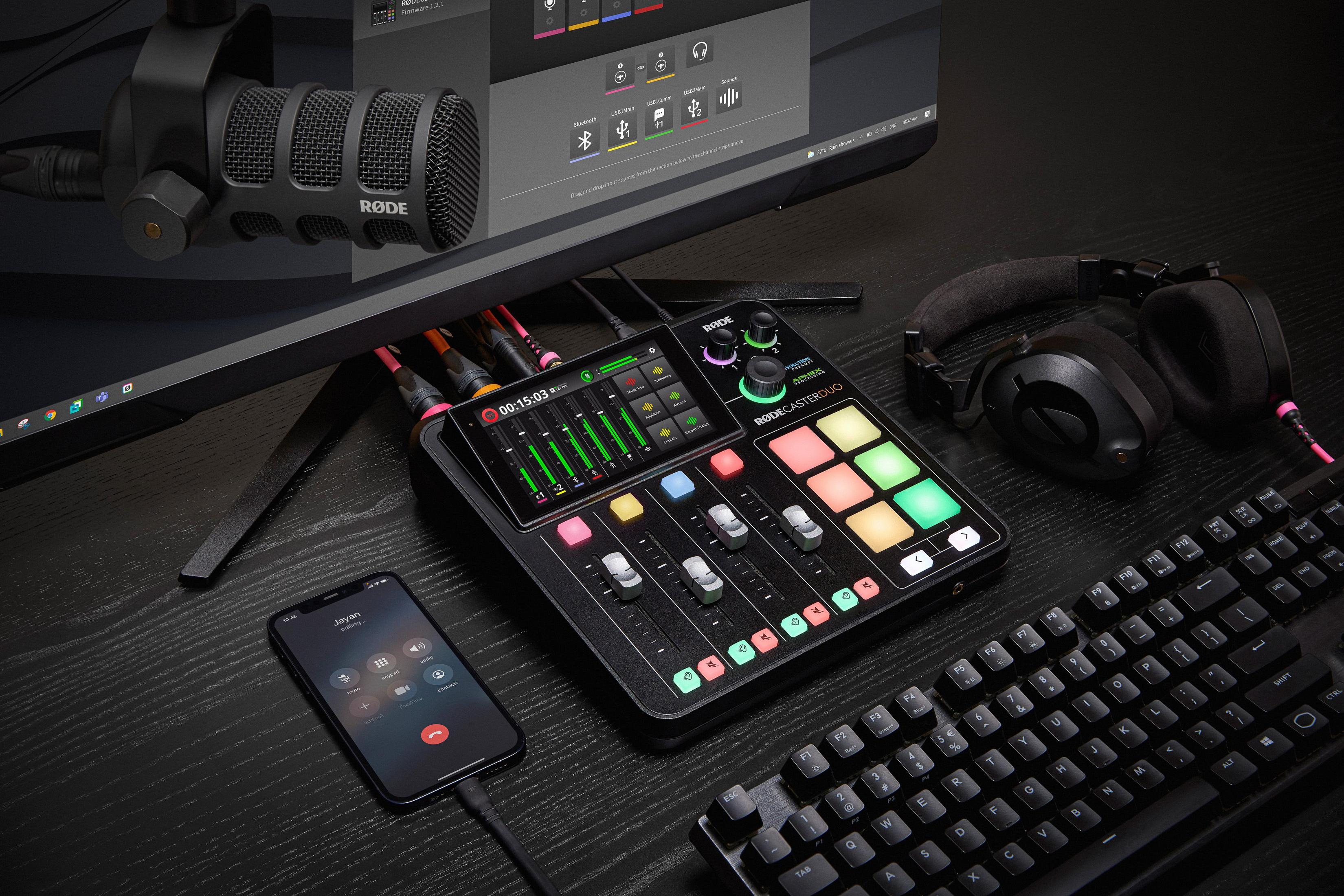 Un setup da studio di registrazione con microfono, interfaccia audio, cuffie, telefono e tastiera.