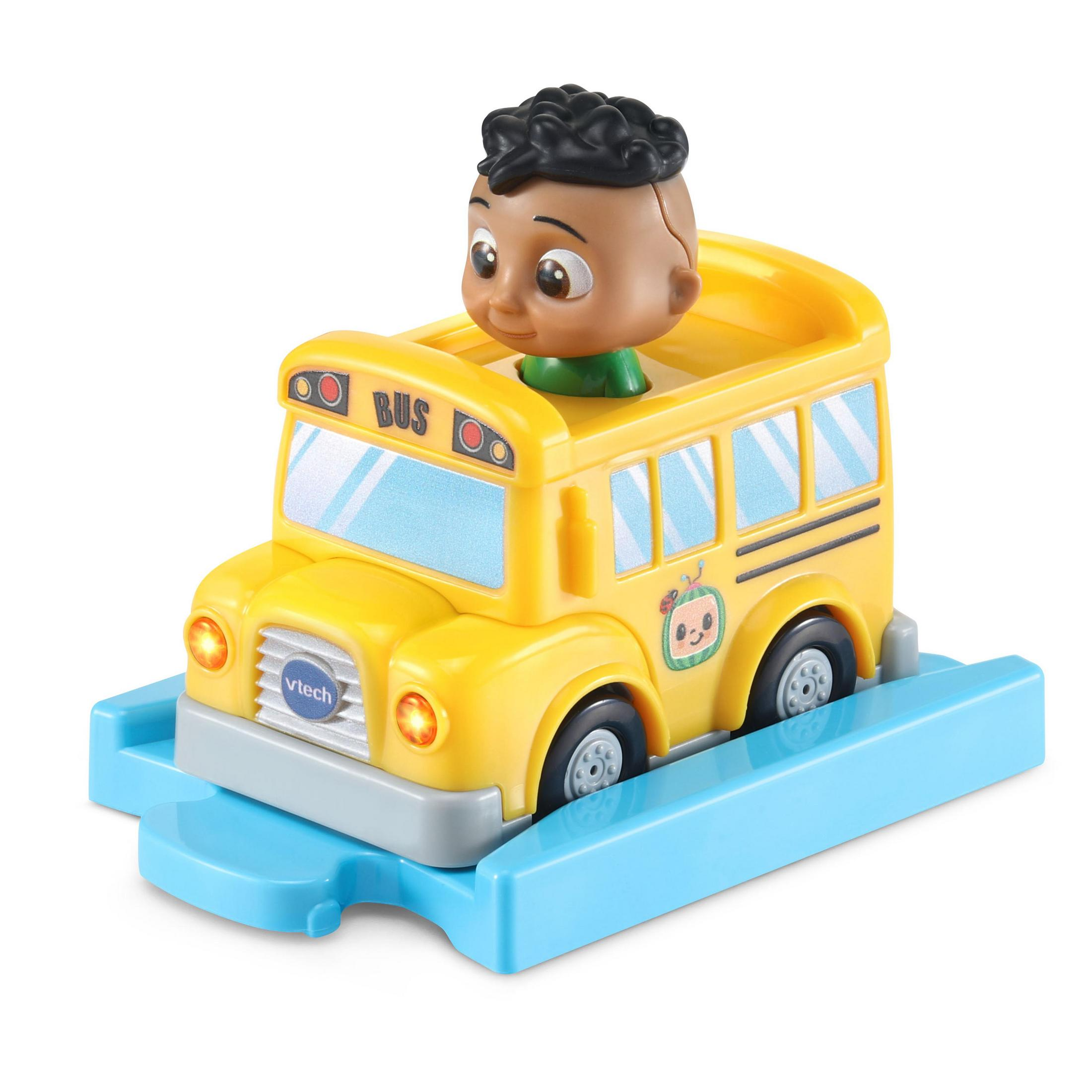 Gelber Spielzeug-Schulbus mit einer lächelnden schwarzen Kinderfigur. Er steht auf einer blauen Plattform.