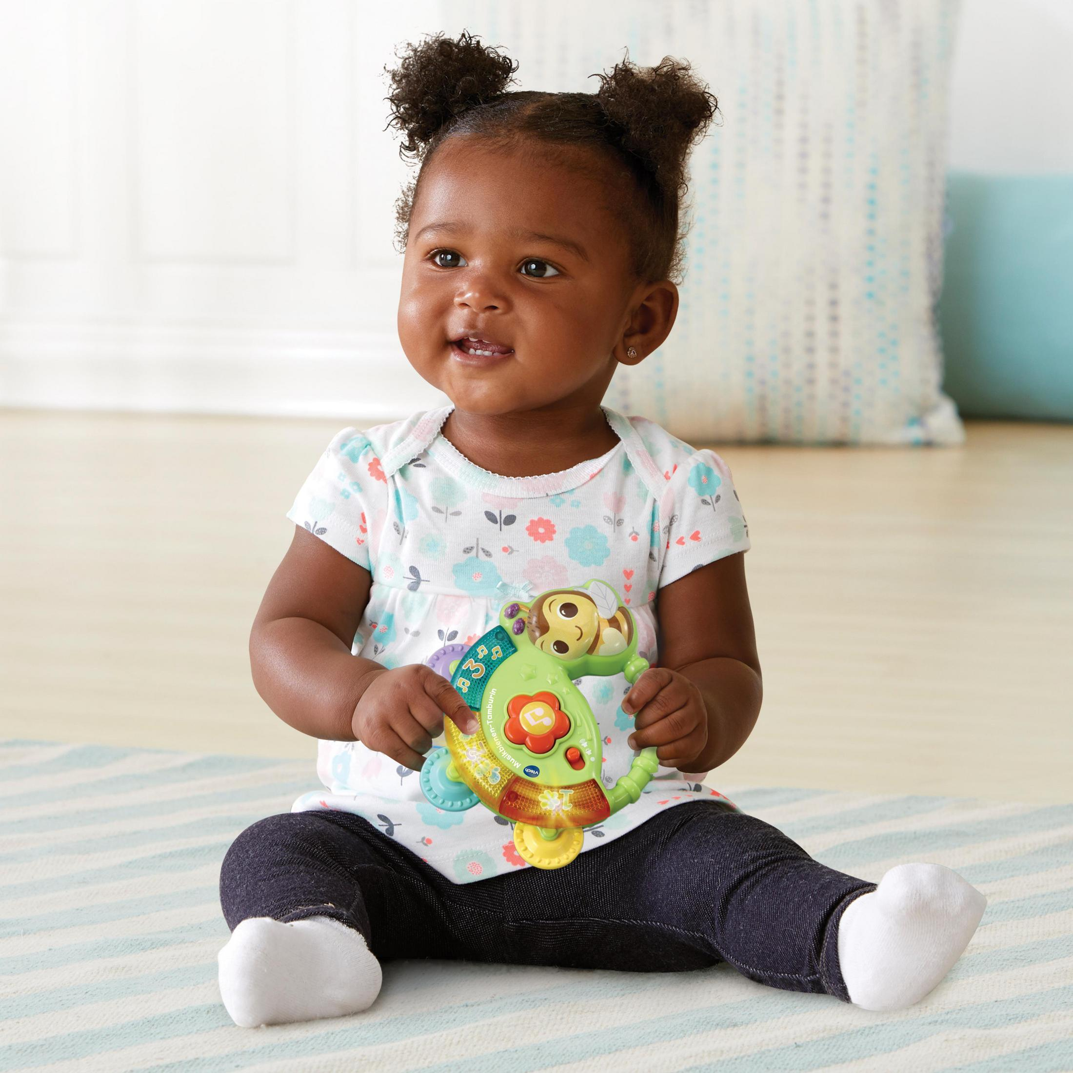 Ein Baby sitzt und hält ein Spielzeug.