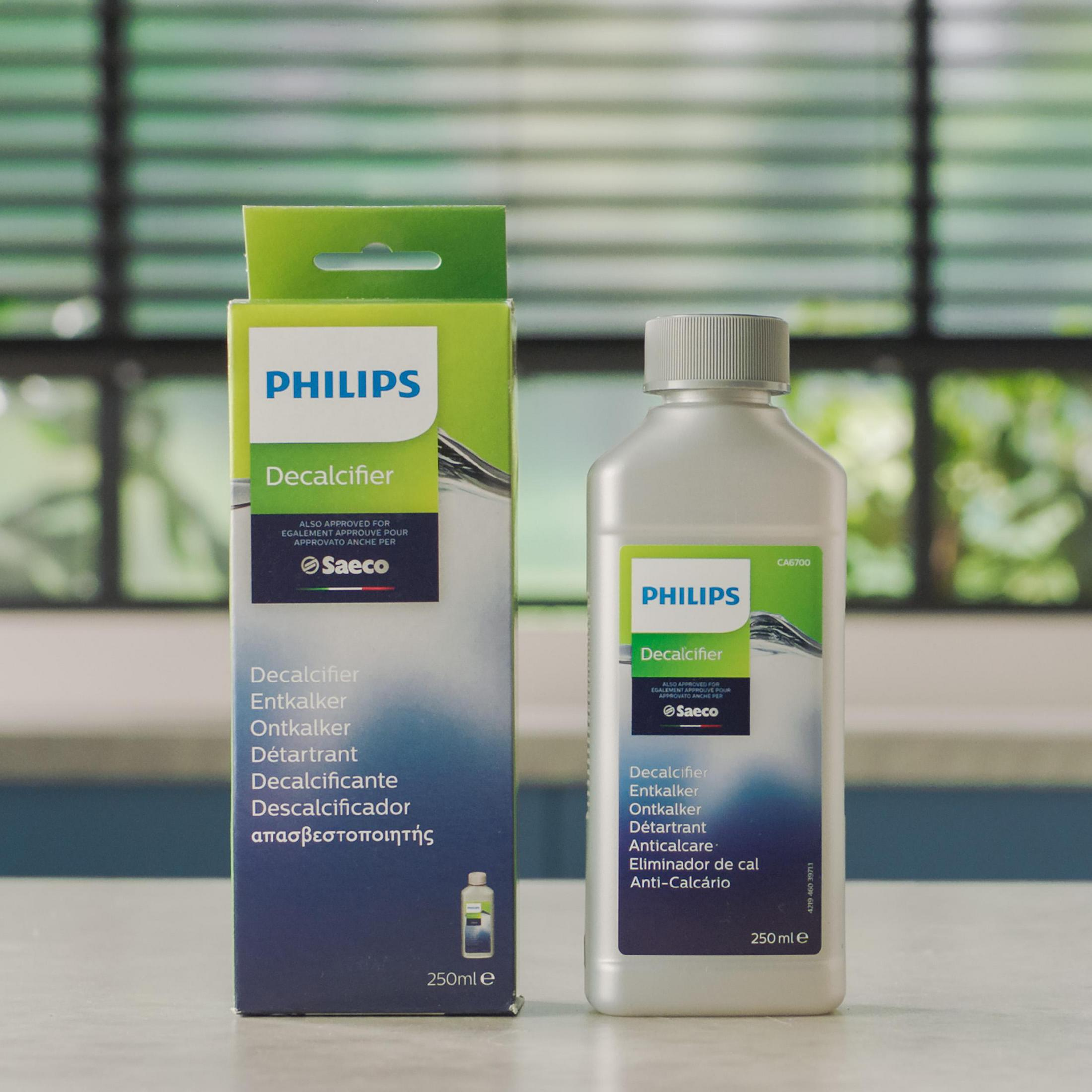 Philips Entkalker-Box und -Flasche auf hellblauem Untergrund, mit hellblauem Hintergrund.