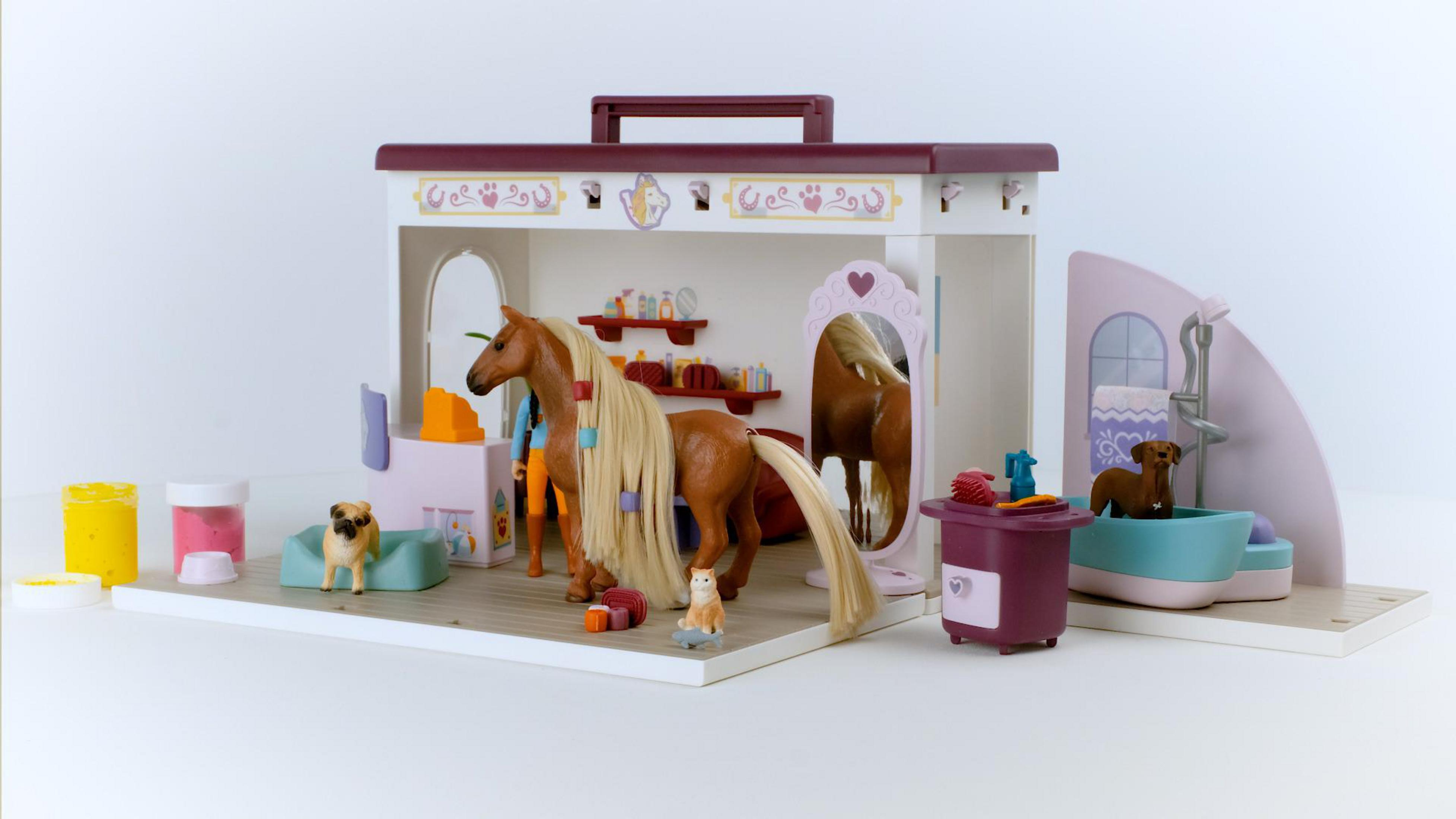 Ein Spielzeug-Tiersalon-Spielset mit Pferd, Hunden, Katze und Zubehör.