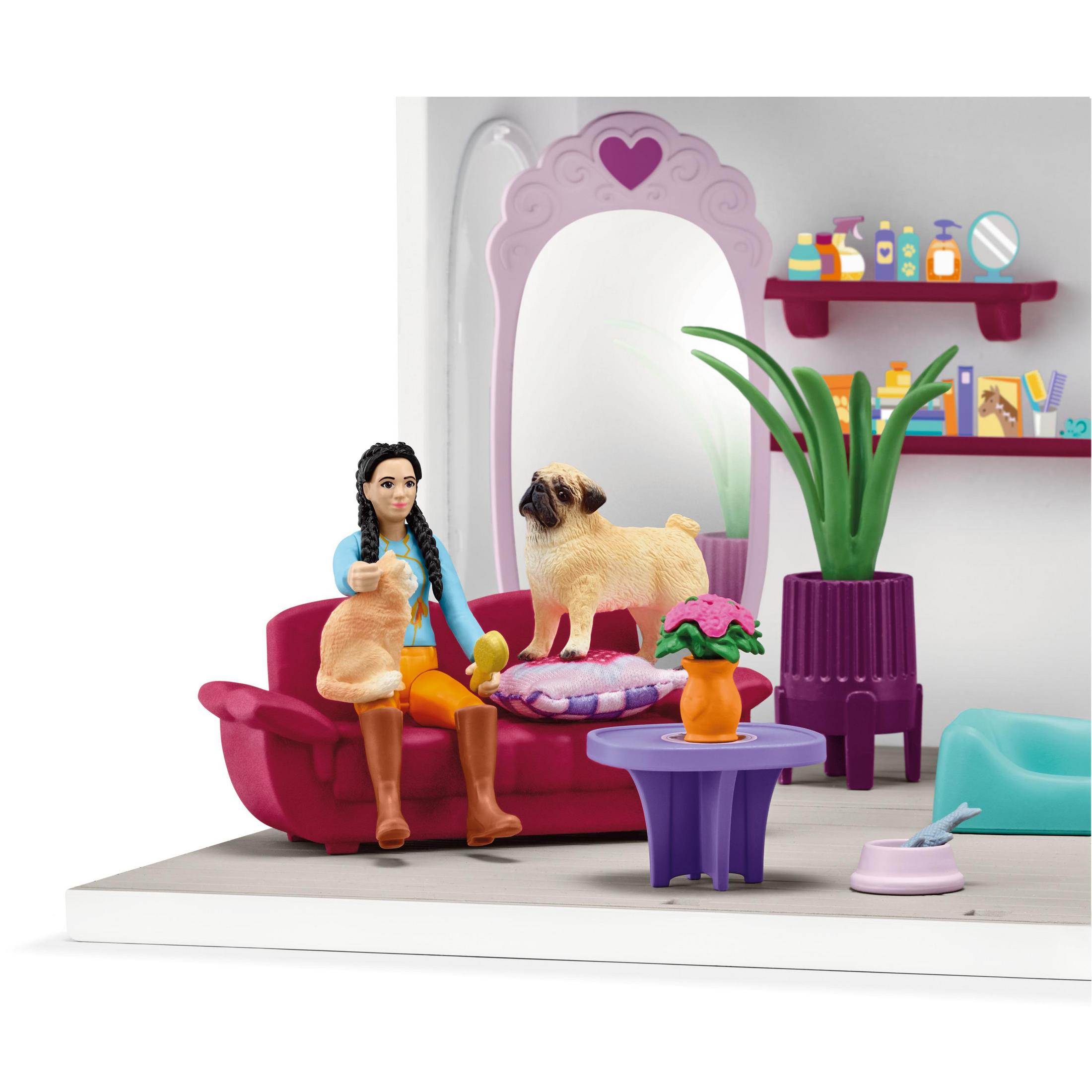 Eine Szene mit einem Mädchen, Hund und Katze in einem Puppenhaus-Wohnzimmer mit Möbeln und Dekor.