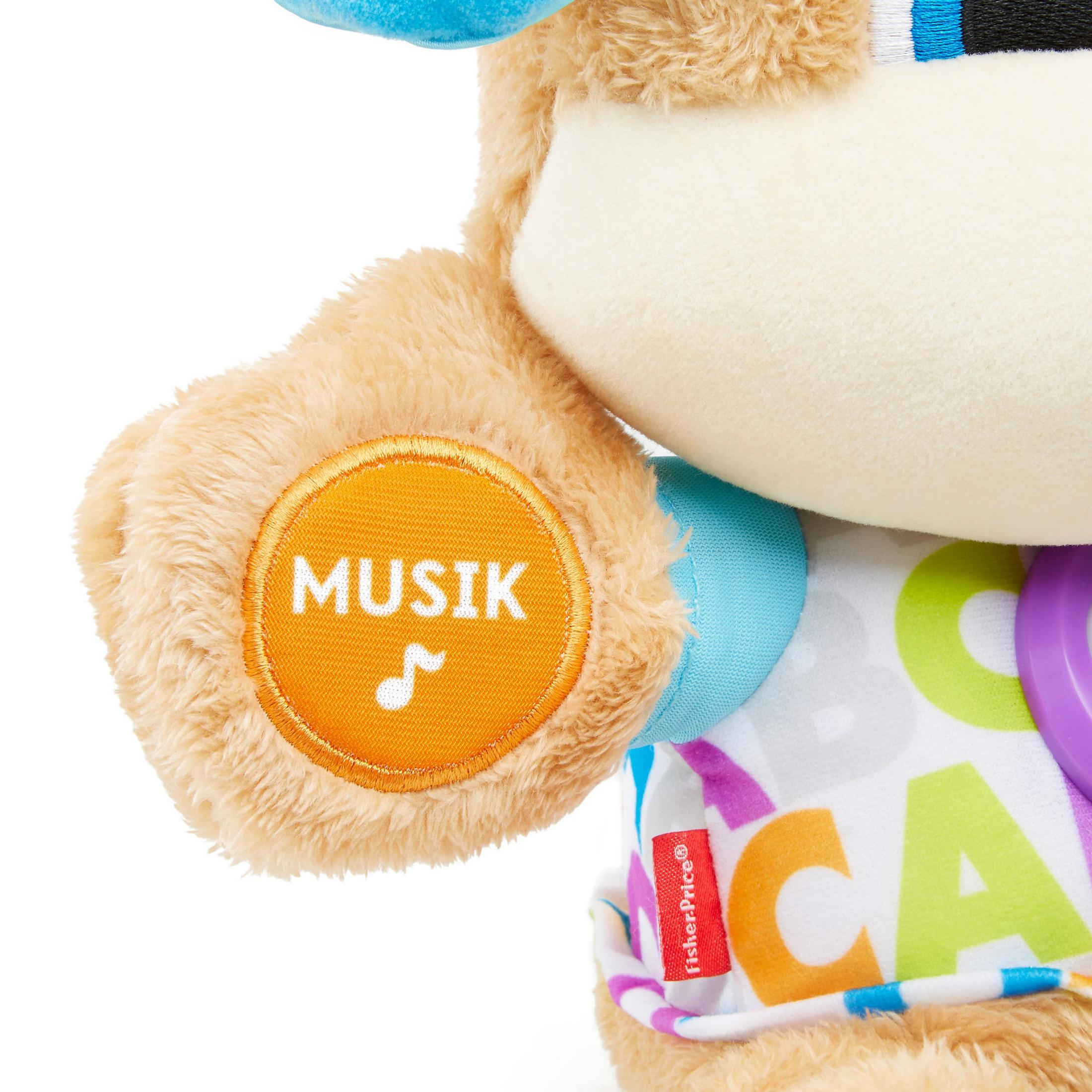 Nahaufnahme der Tatze eines Spielzeugbären mit Musiksymbol und dem Wort 'Musik'.