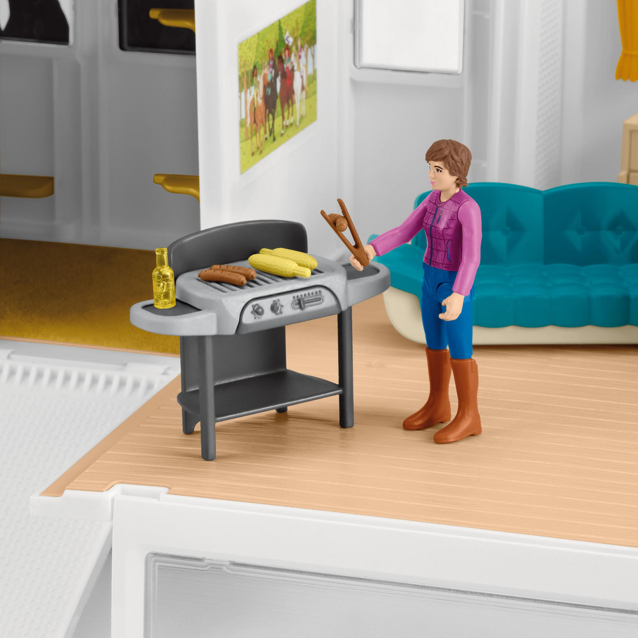 Scena z zabawkami z kobietą grillującą jedzenie na szarym grillu. Obok stół z butelką i kukurydzą.