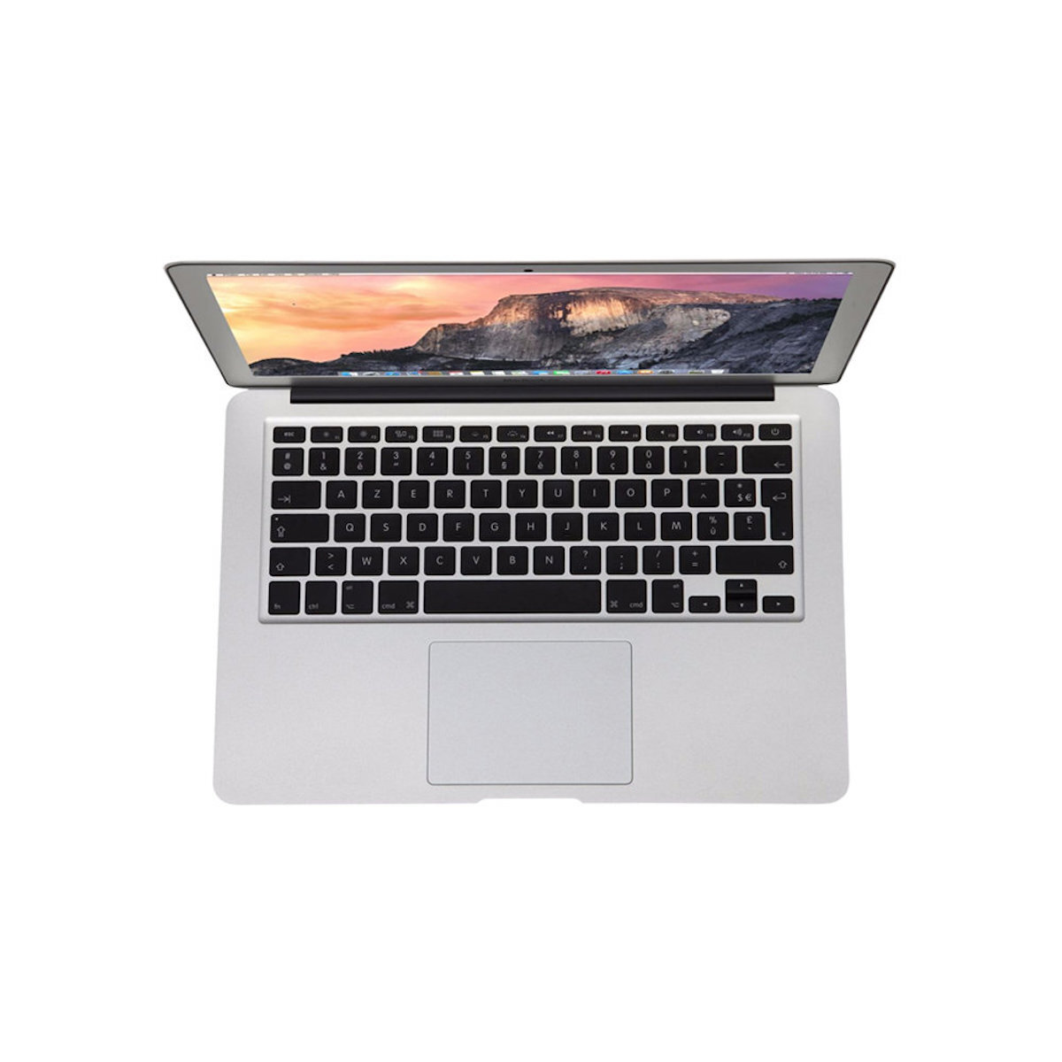 Un portátil plateado con la pantalla abierta mostrando un paisaje montañoso. El teclado es visible.