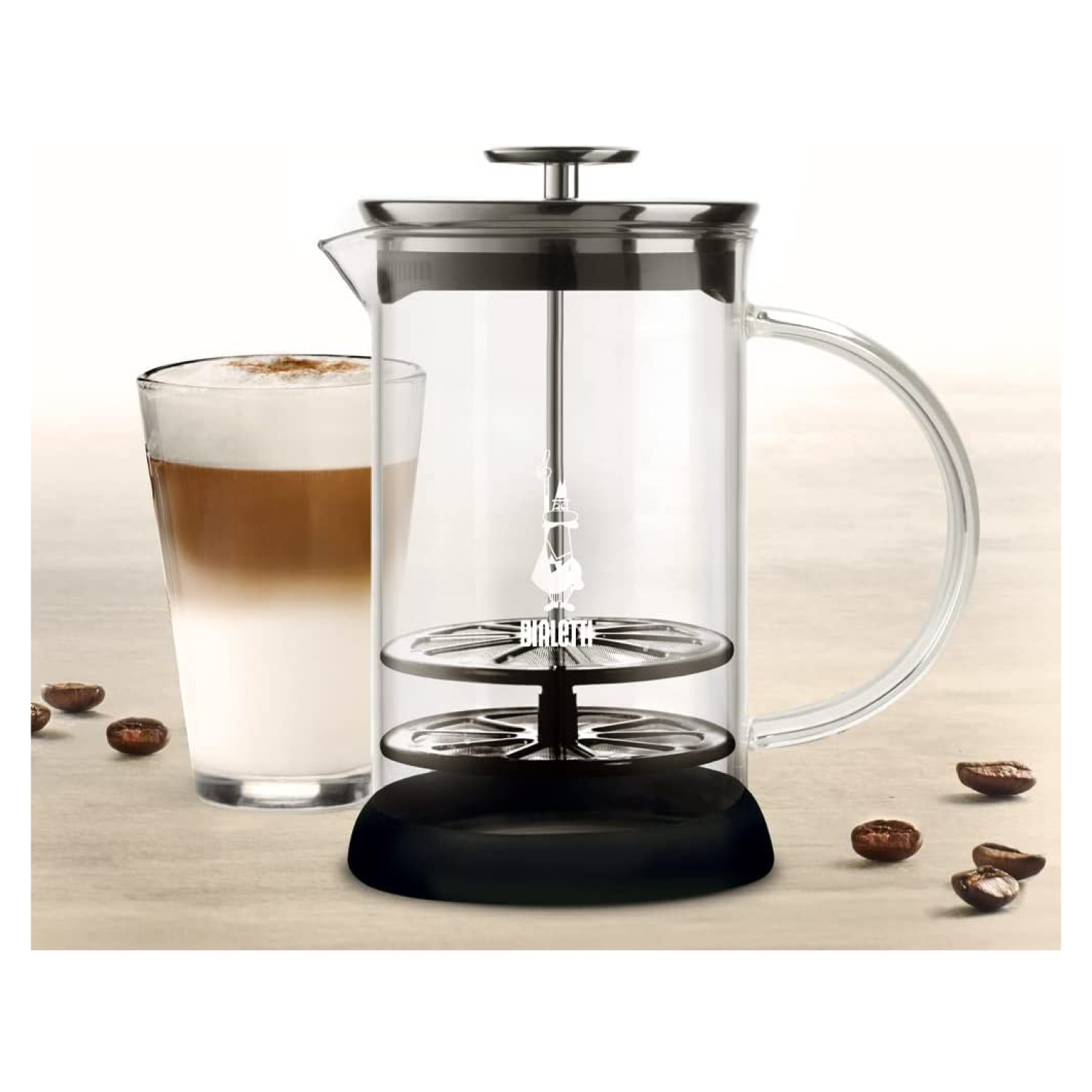 Kawiarka French press ze szklaną karafką i filiżanką latte. Ziarna kawy wokół.