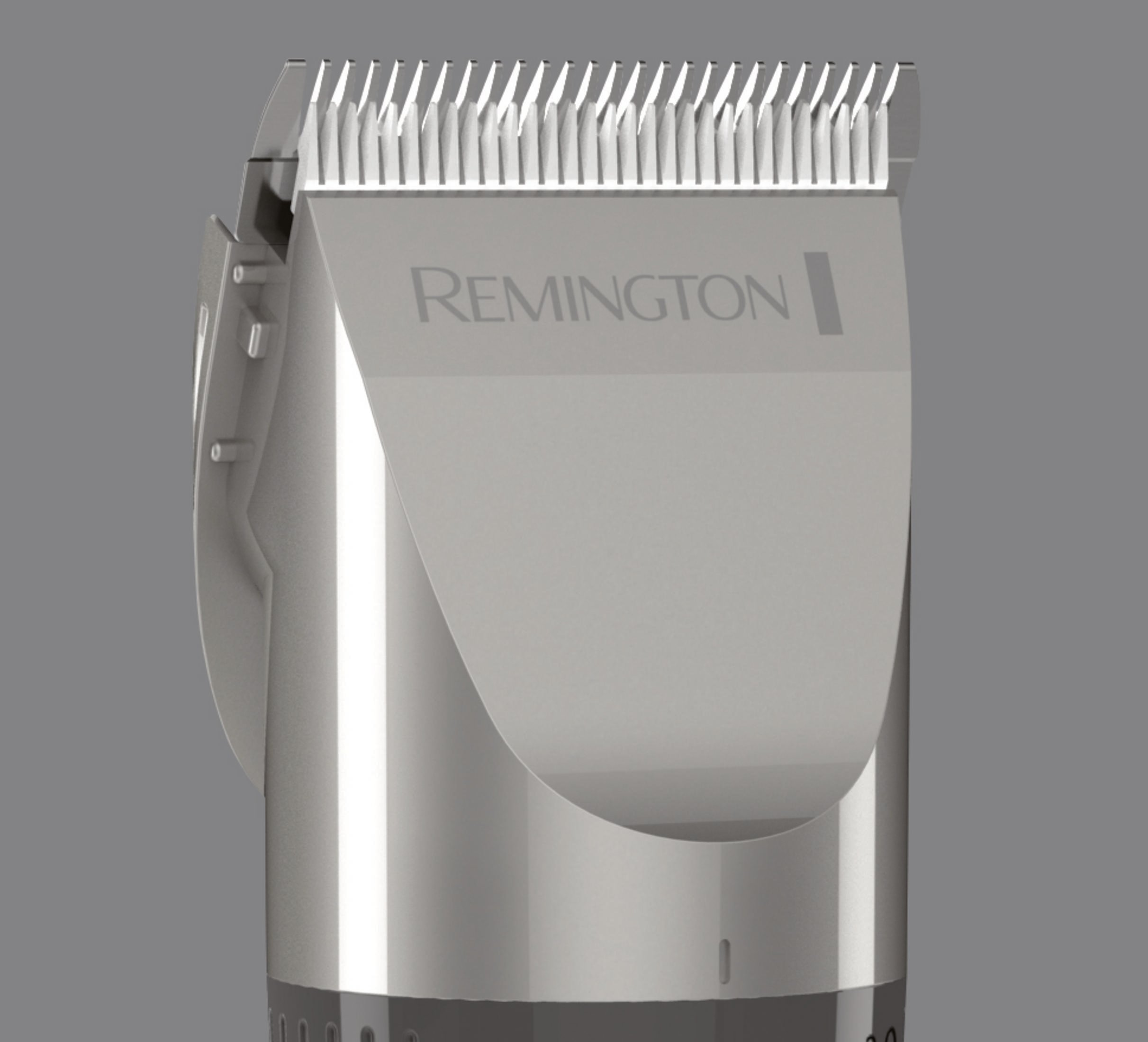 Recortadora de cabello Remington plateada. Vista de cerca, en ángulo, sobre un fondo gris.