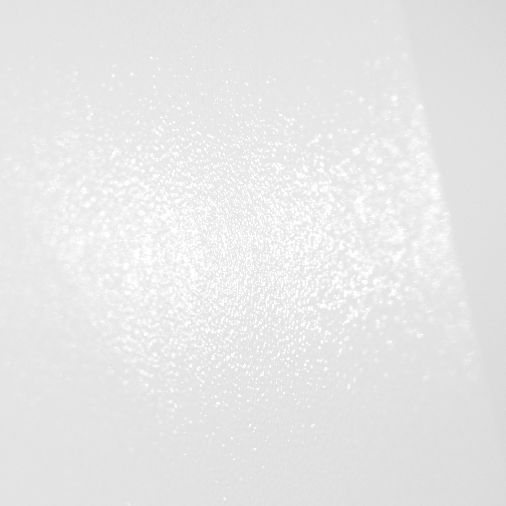 Weiße Oberfläche mit Lichtreflexion und Textur, leicht unscharf.