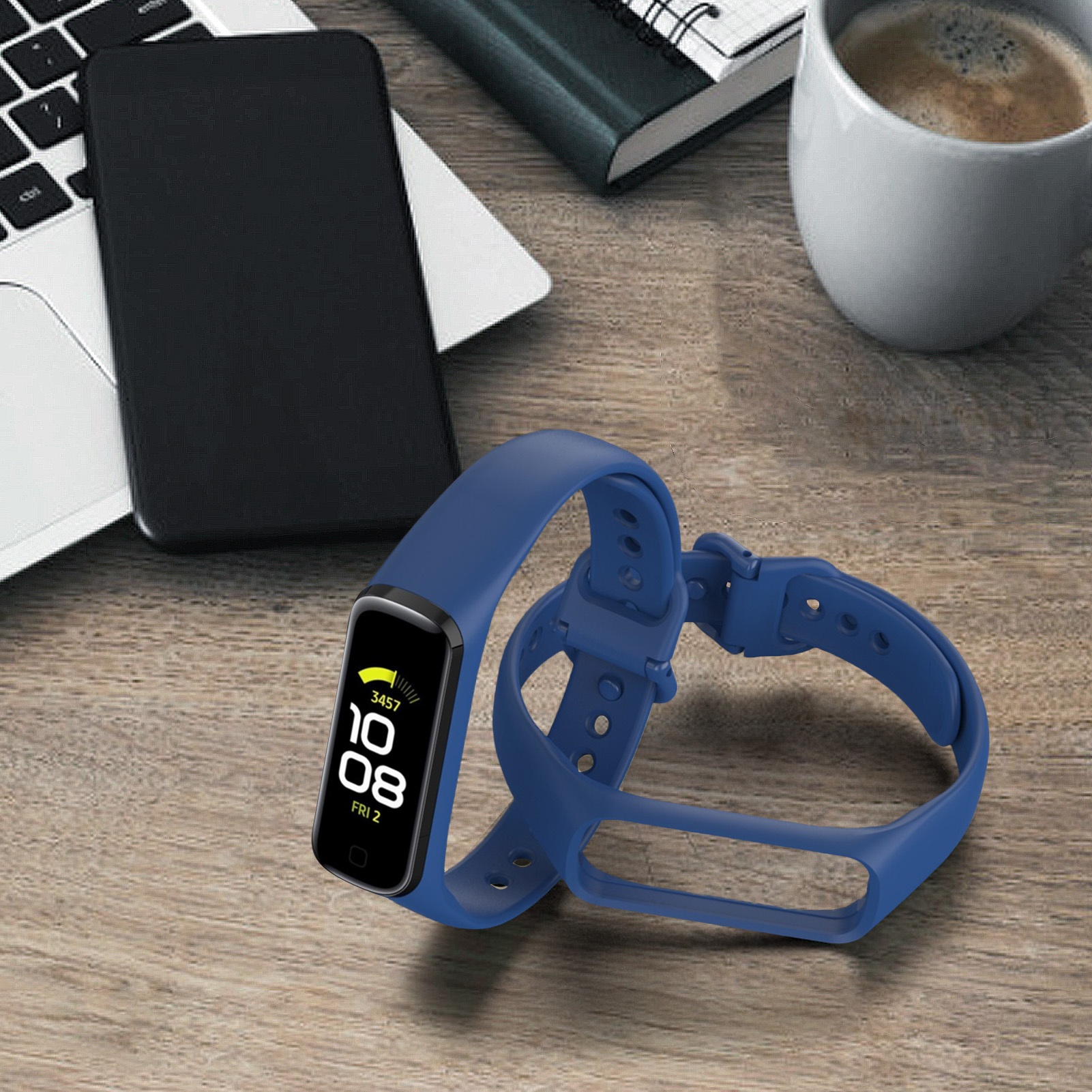 Blaues Smartwatch-Armband und Telefon neben Laptop und Kaffeetasse auf Holzschreibtisch.