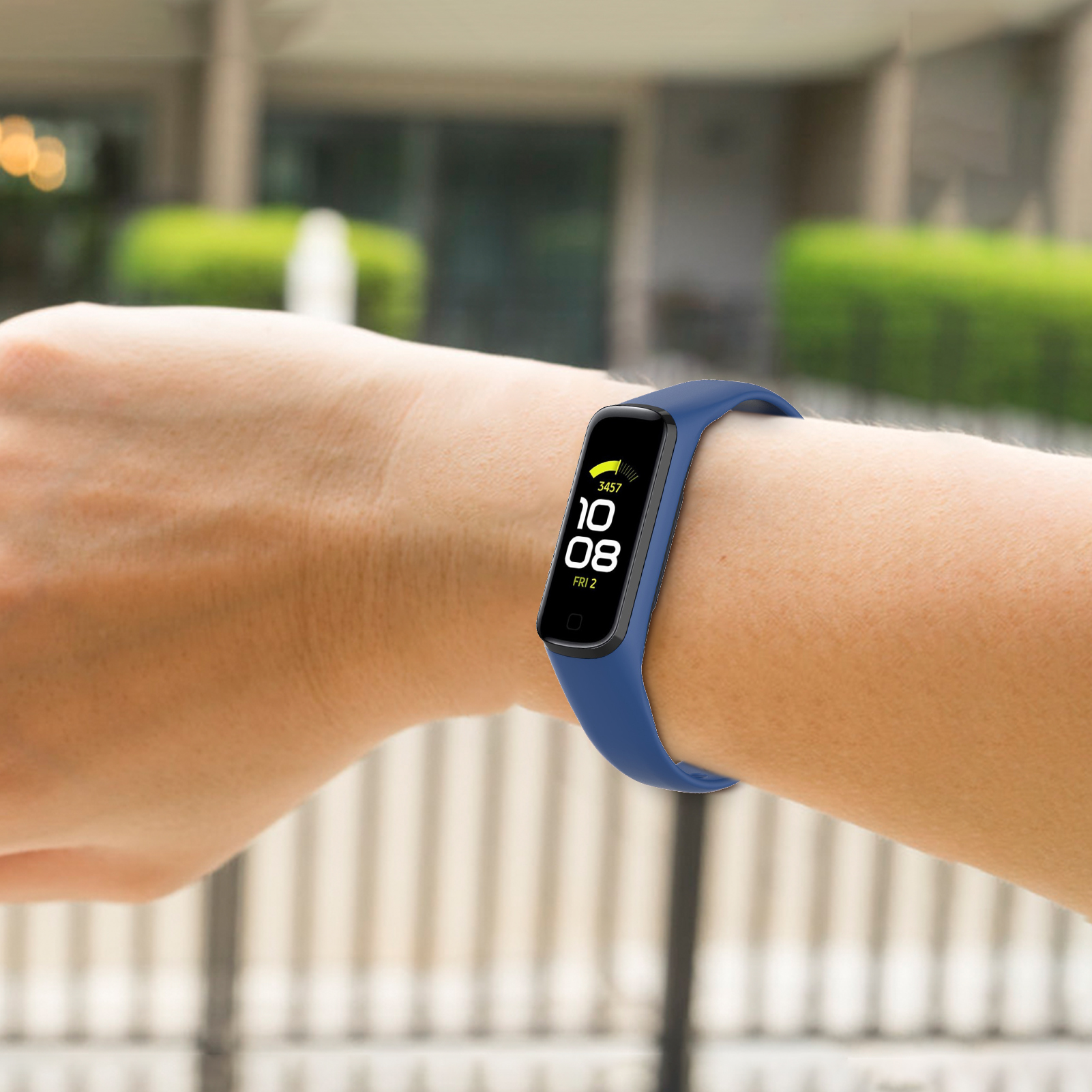 Person trägt blaues Smartband am Handgelenk, zeigt Zeit und Schritte, draußen.