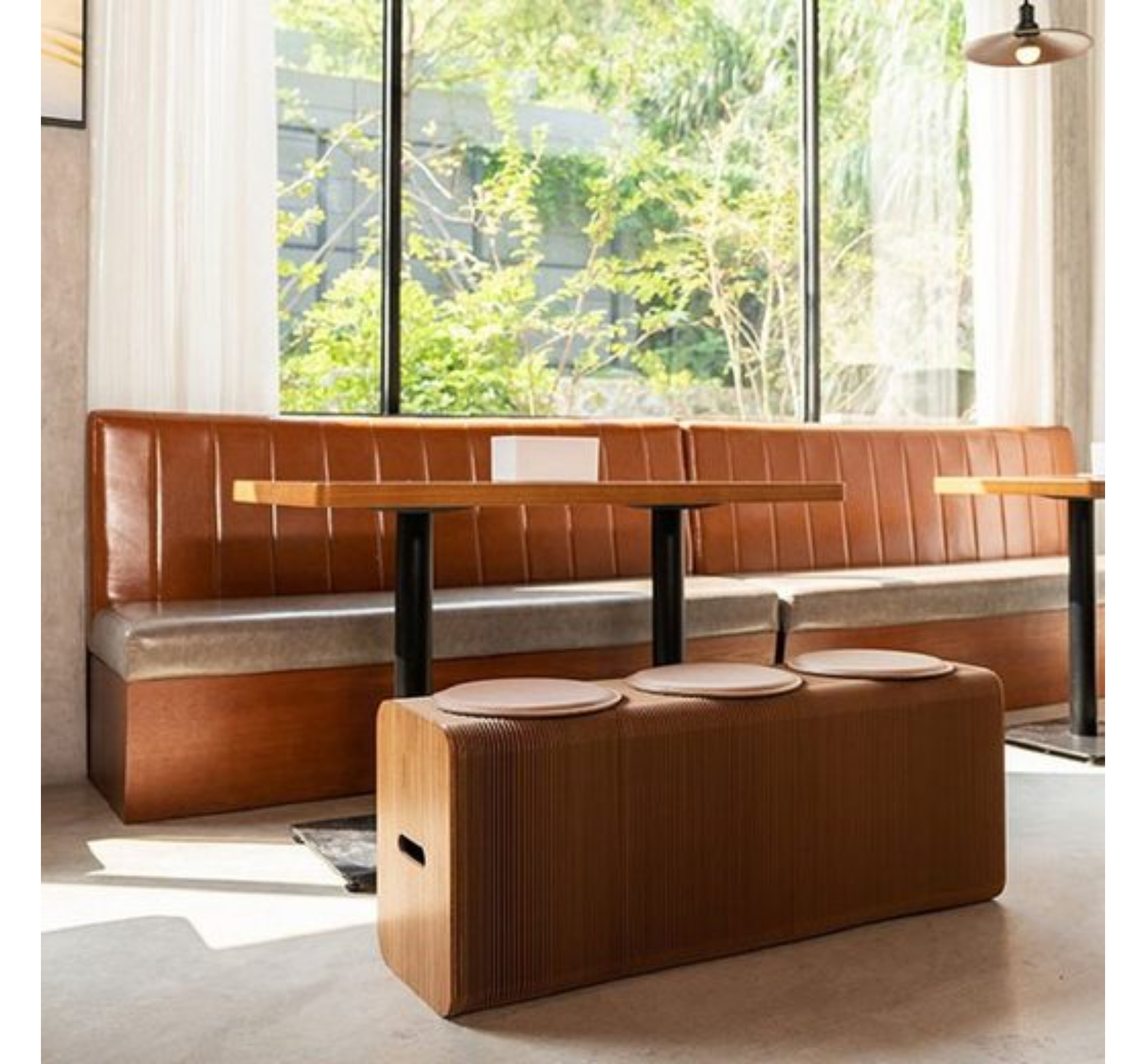 Restaurant-Interieur. Braune Leder-Sitzgruppe mit Tischen und einer braunen Sitzbank für mehrere Personen.