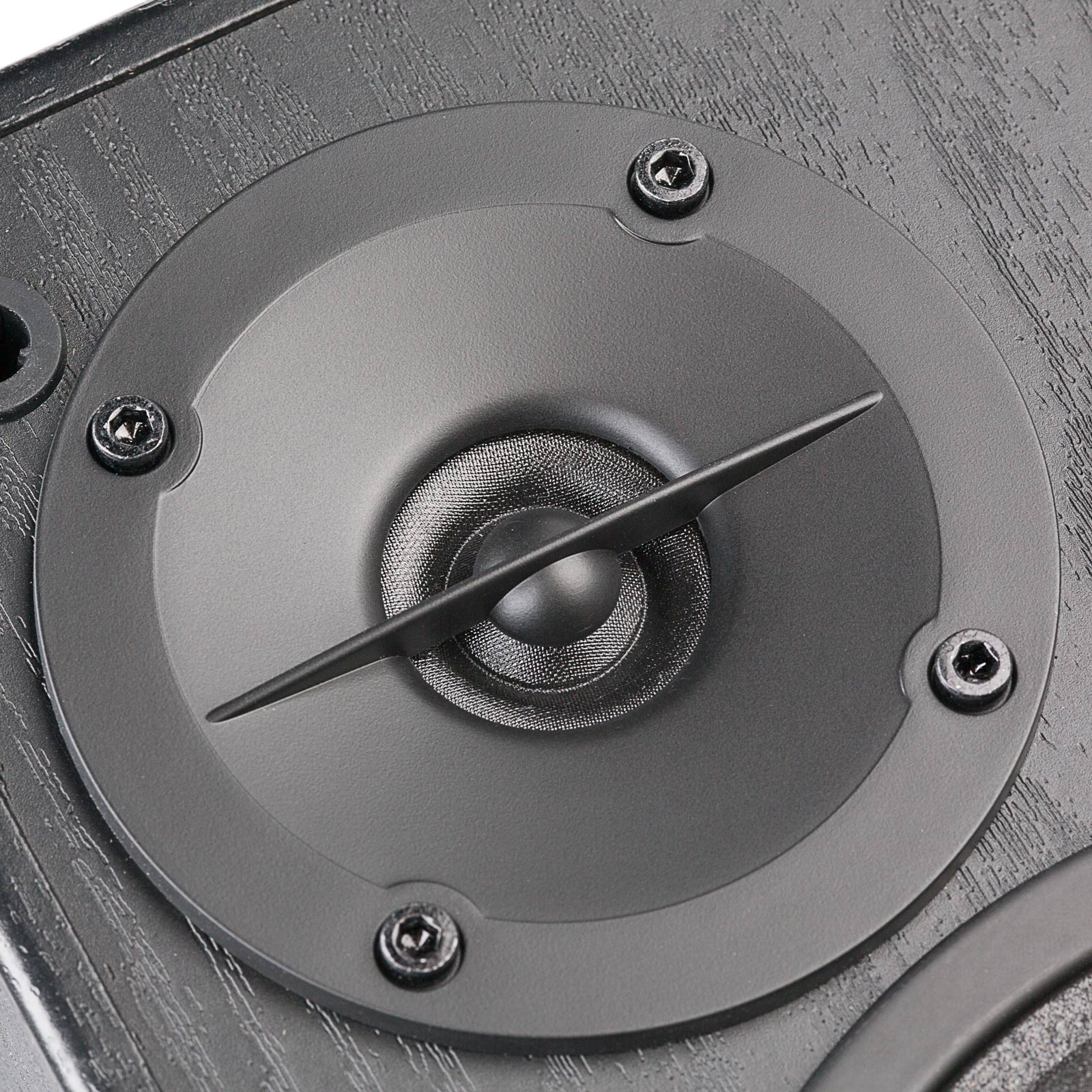 Zbliżenie przetwornika głośnikowego z czarnym stożkiem, otoczonego okrągłą ramą i śrubami.