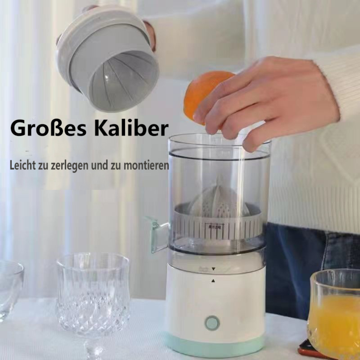 Person presst Orange in Entsafter, Teile daneben. Glas mit Saft.