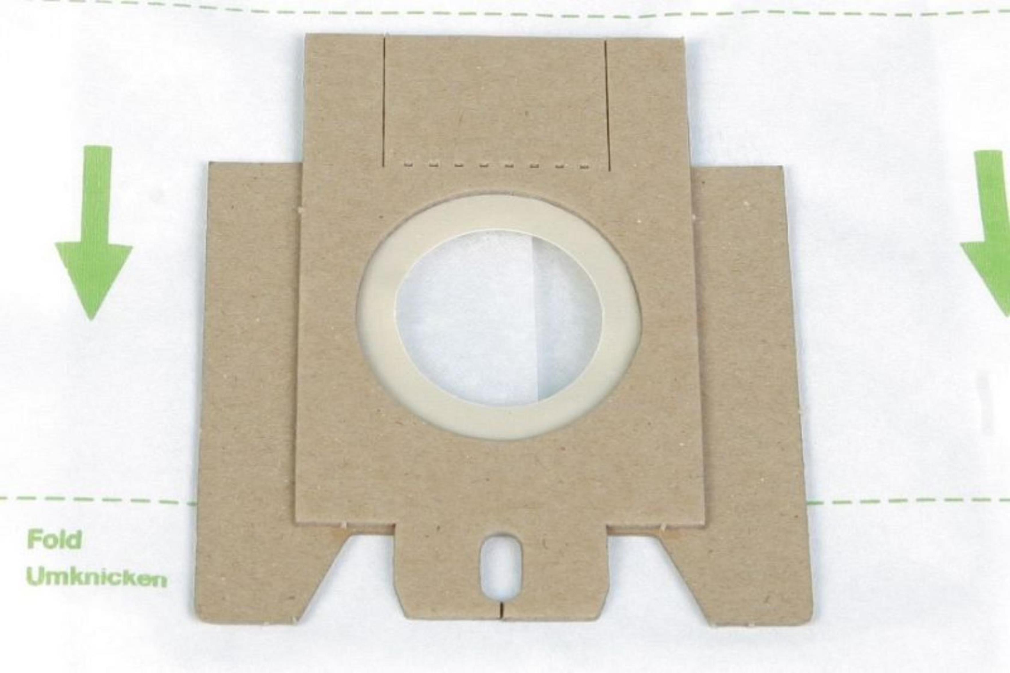 Ein brauner Papierstaubsaugerbeutel mit kreisförmiger Öffnung und grünen Faltlinien.