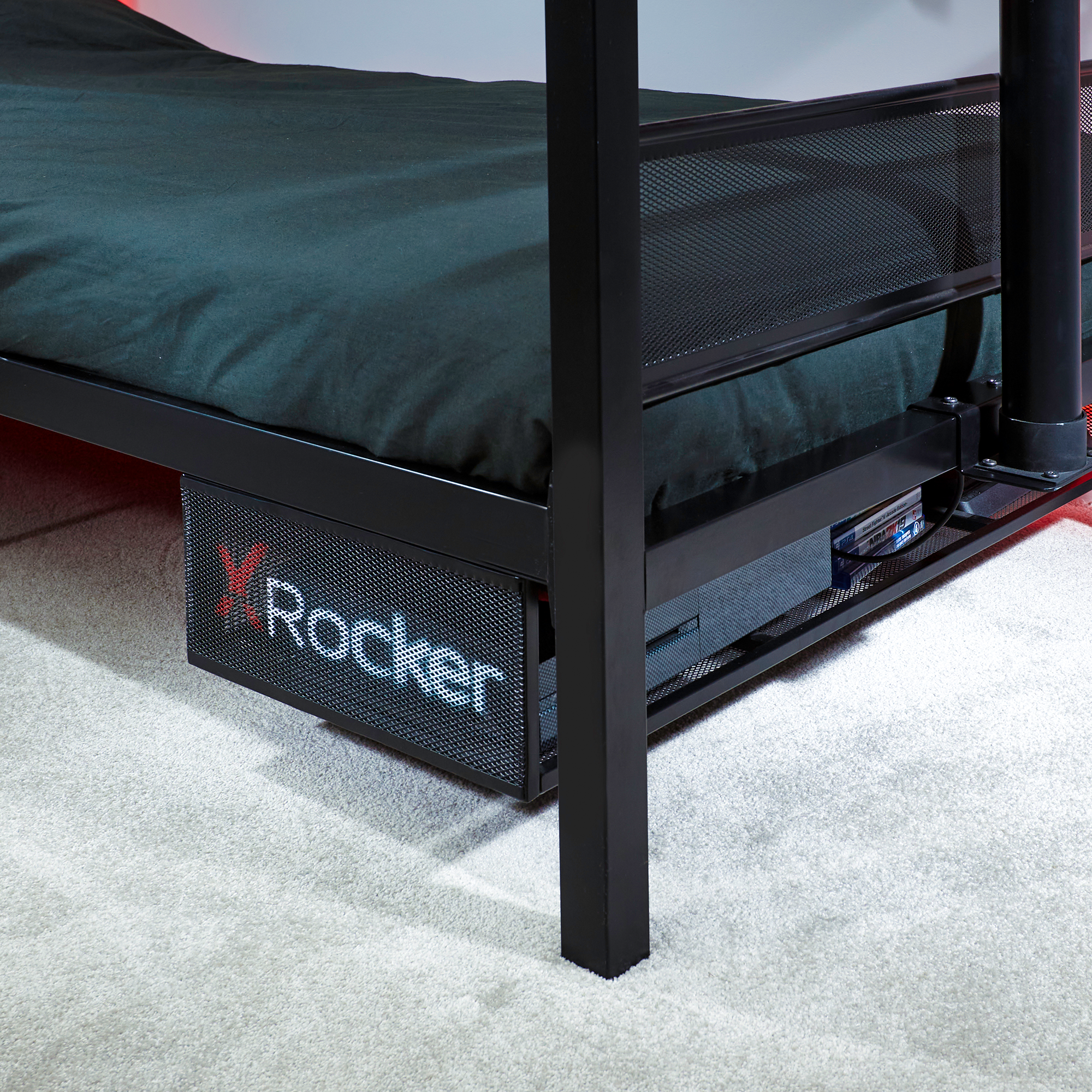Schwarzes Etagenbett mit Rocker-Logo auf der Frontplatte, auf grauem Teppich.