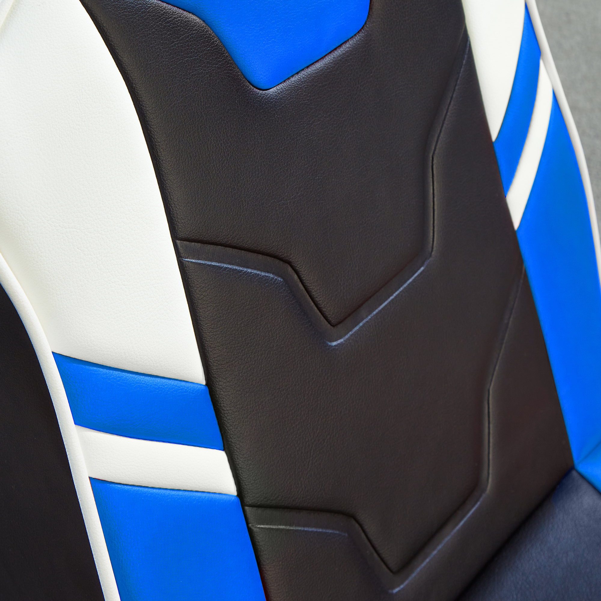Nahaufnahme eines Gaming-Stuhlsitzes. Der Sitz ist schwarz, weiß und blau. Der Rücken ist schwarz.