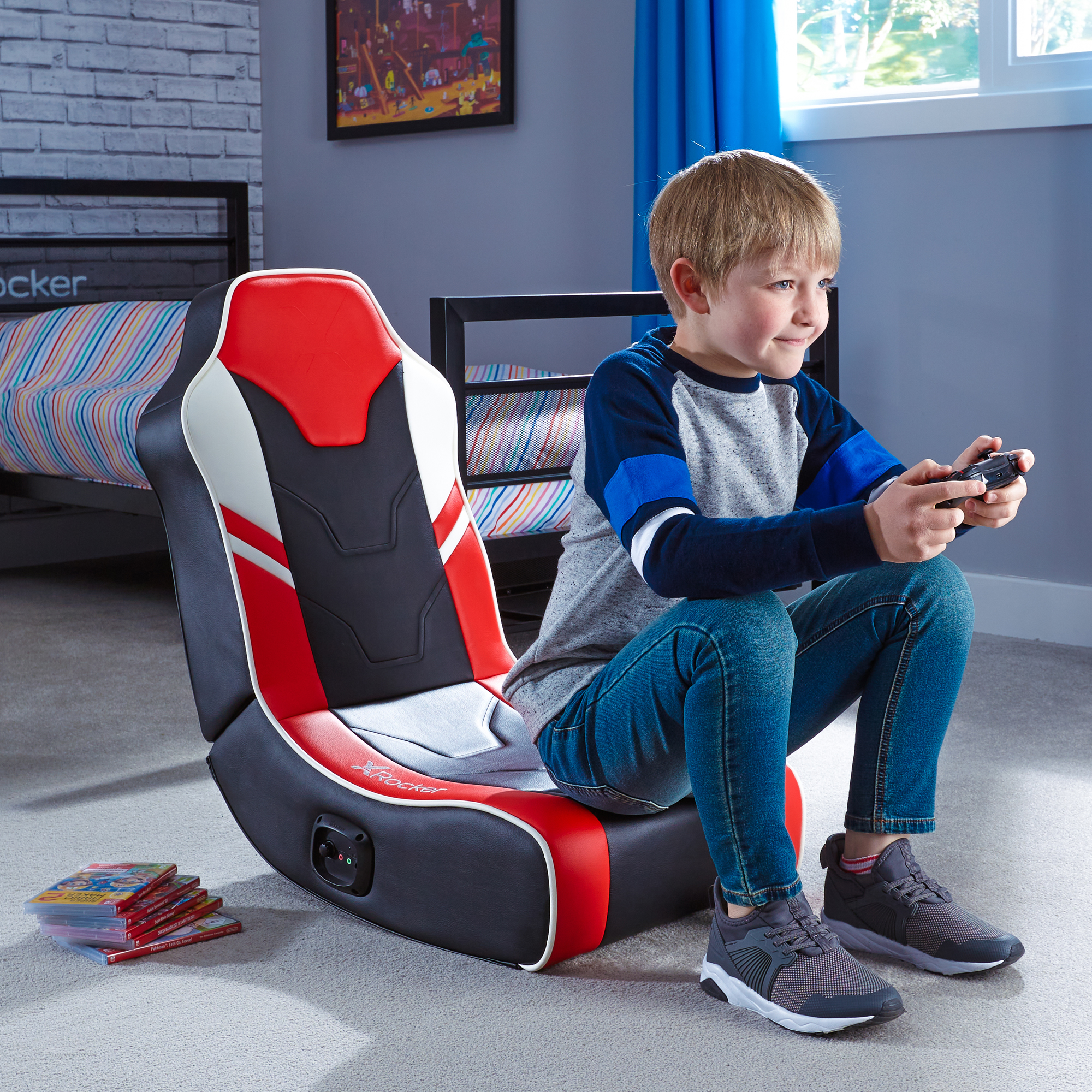 Junge sitzt in einem Gaming-Stuhl, spielt Videospiel. Vordergrund: Junge, Stuhl. Hintergrund: Zimmer.