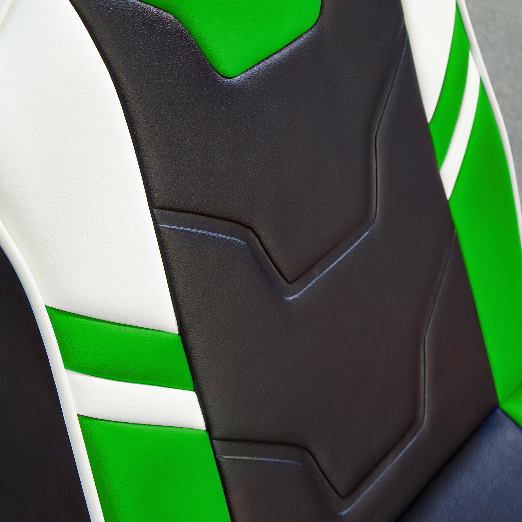 Detail des Gaming-Stuhls mit schwarzen, grünen und weißen Bereichen. Grauer Hintergrund.