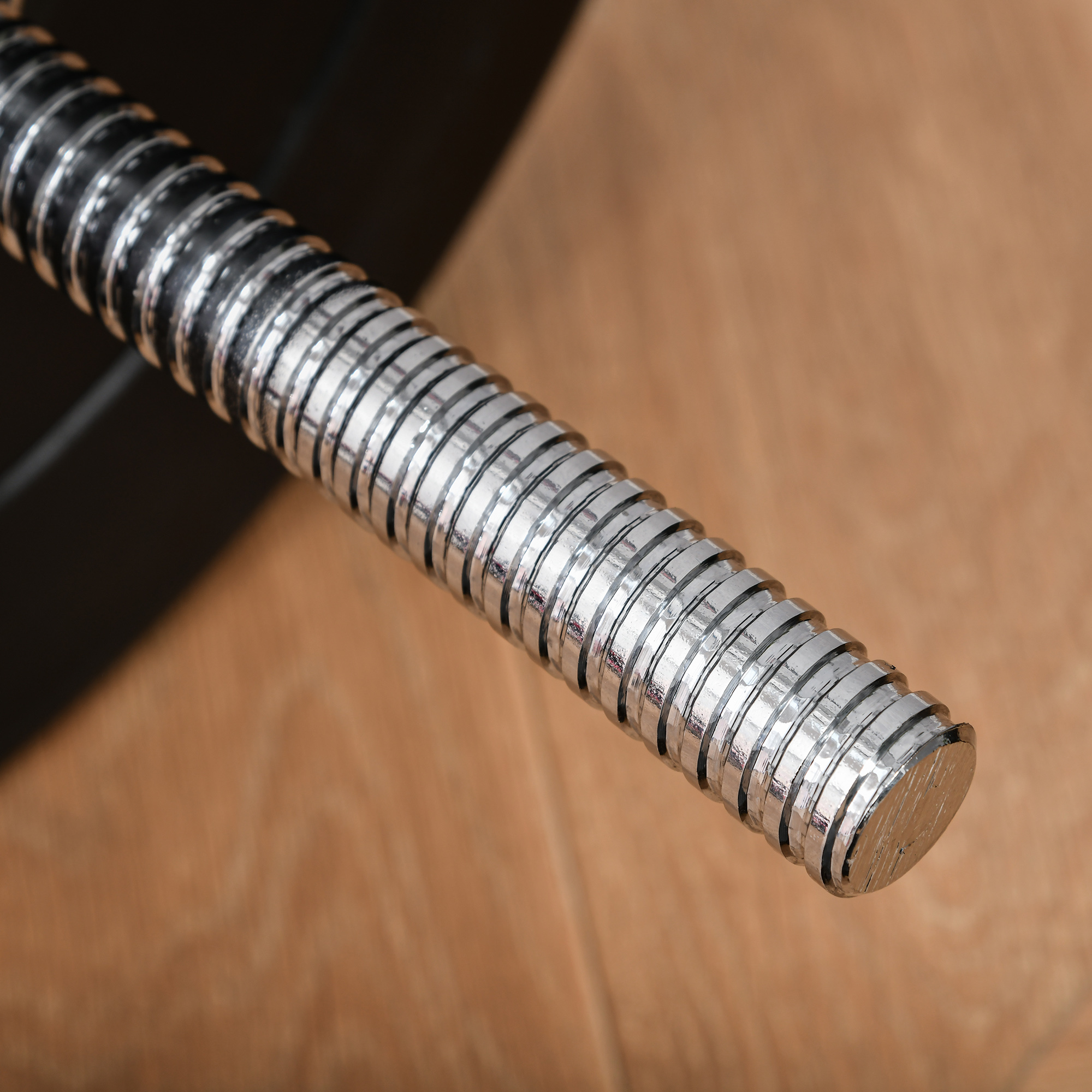 Primer plano de una manguera flexible, metálica y acanalada. Muestra el detalle de las espirales metálicas.